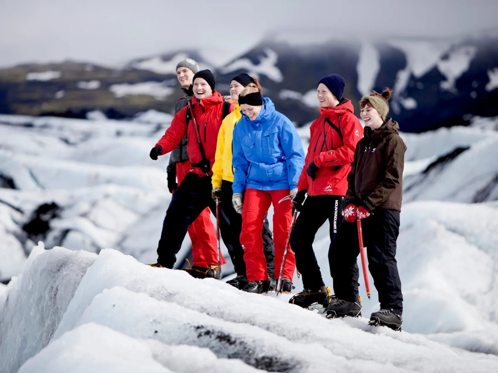 6 Personen lachend bei einer Gletscherwanderung in Island