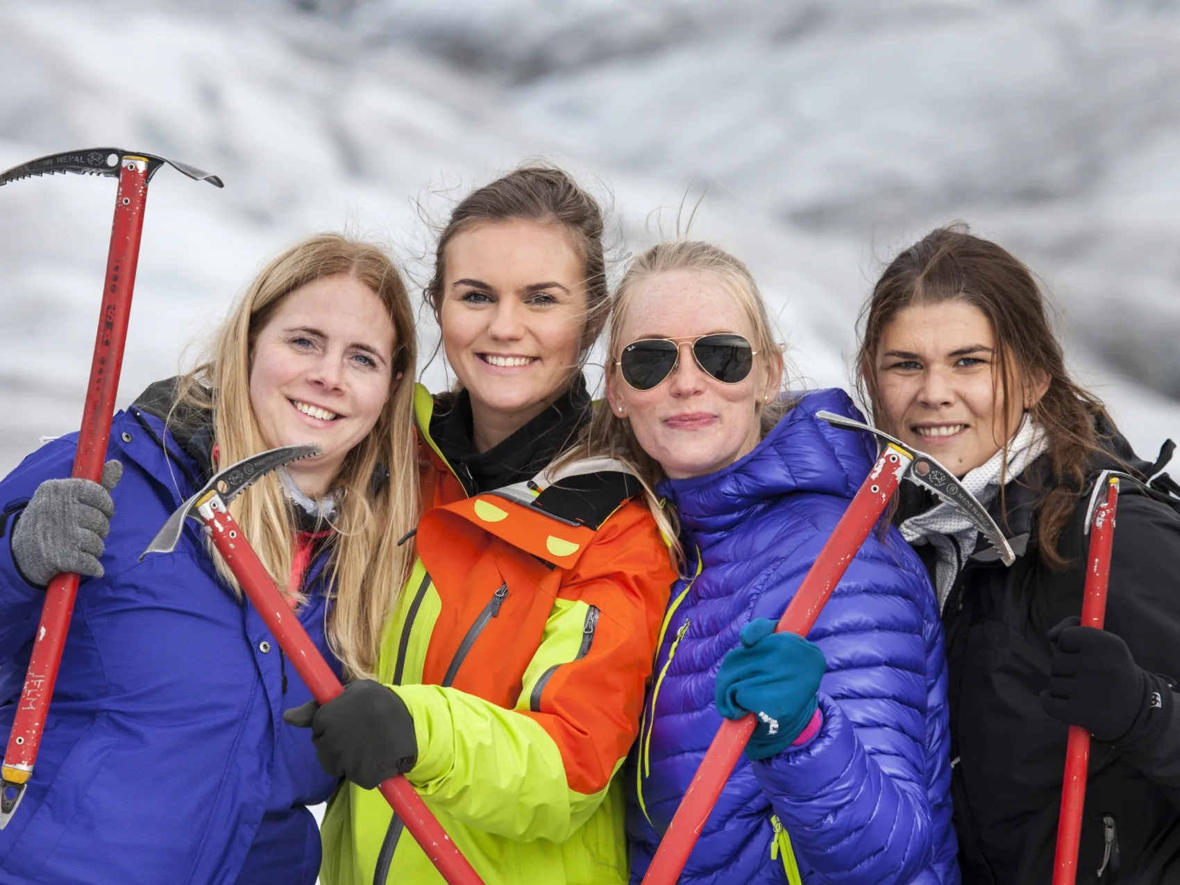 Vier Personen mit Spitzhacken auf einem Gletscher in Island