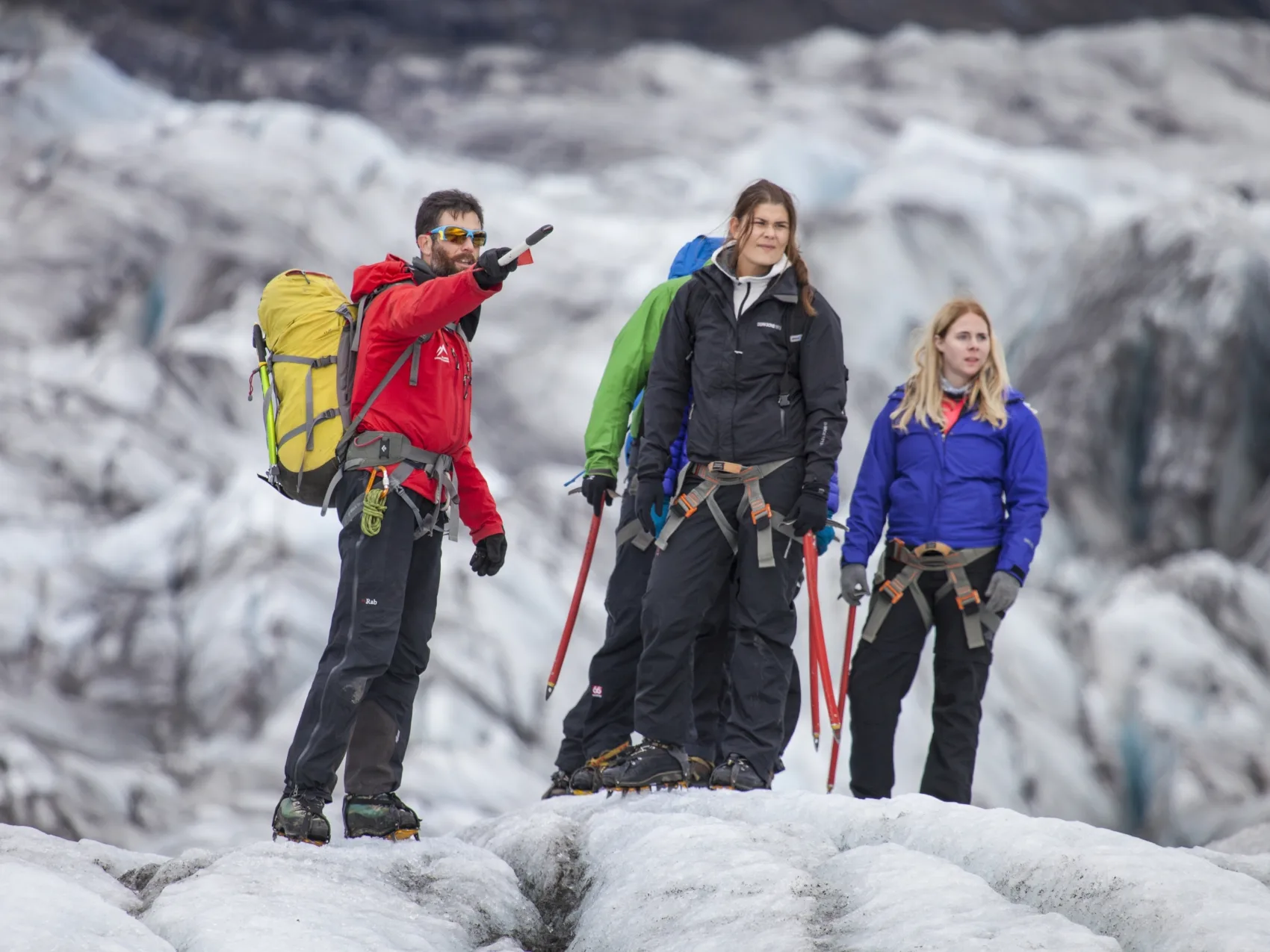 Guide zeigt der Reisegruppe etwas in der Ferne bei einer Gletscherwanderung auf dem isländischen Gletscher Svinafellsjökull