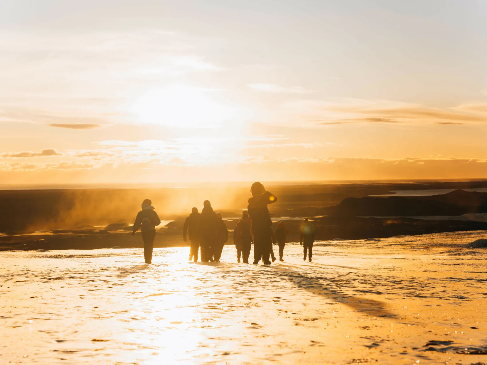 Eine Reisegruppe, die im Sonnenuntergang auf einem Gletscher in Island wandert