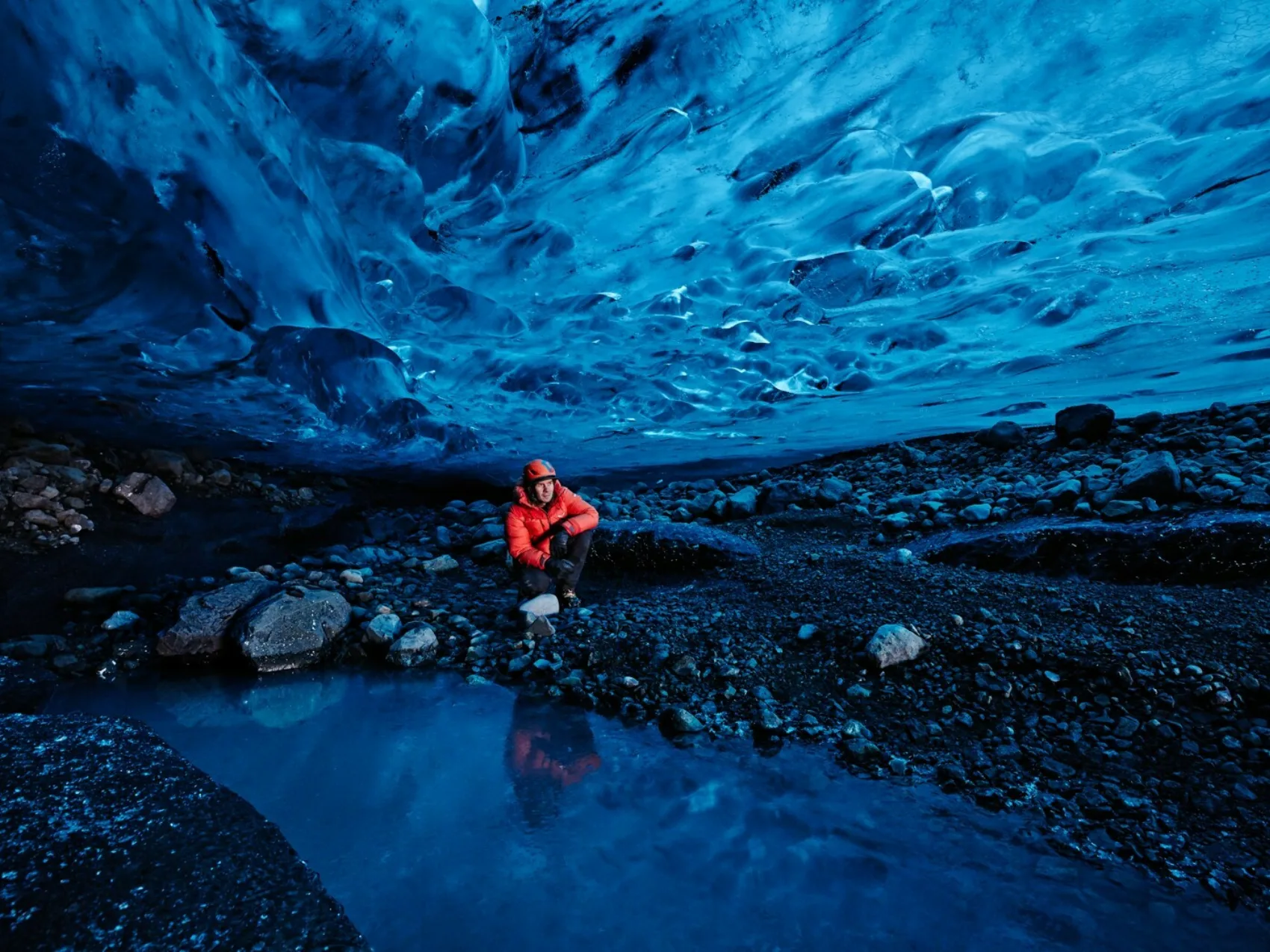 Ein Tourführer in einer engen Eishöhle in Island