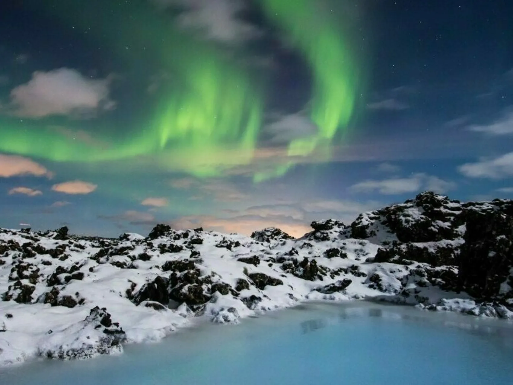 Schneebedeckte Berge um die blaue Lagune, Nordlichter im Himmel, Island Reisen