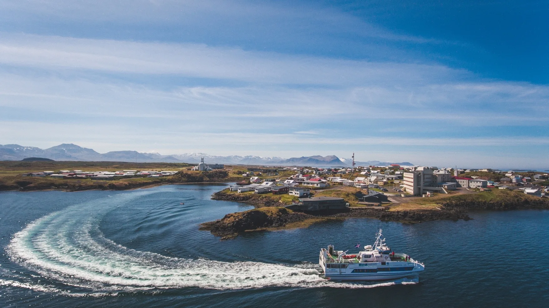 Luftansicht eines Bootes, das gerade einen Hafen in Island verlässt