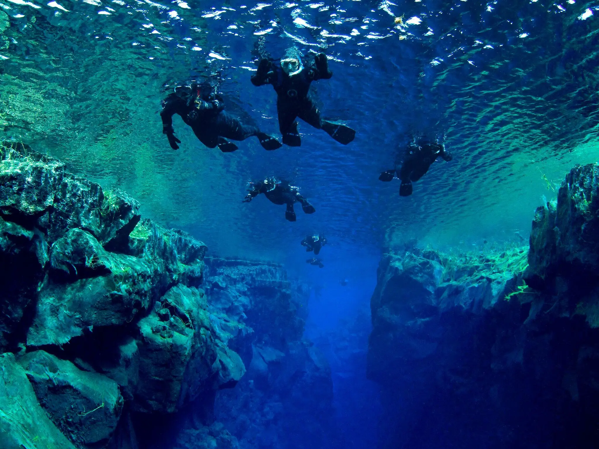 Schnorchel Gruppe in Siflra Eine Gruppe von Schnorchlern in der Silfra spalte dunkelblaues Wasser