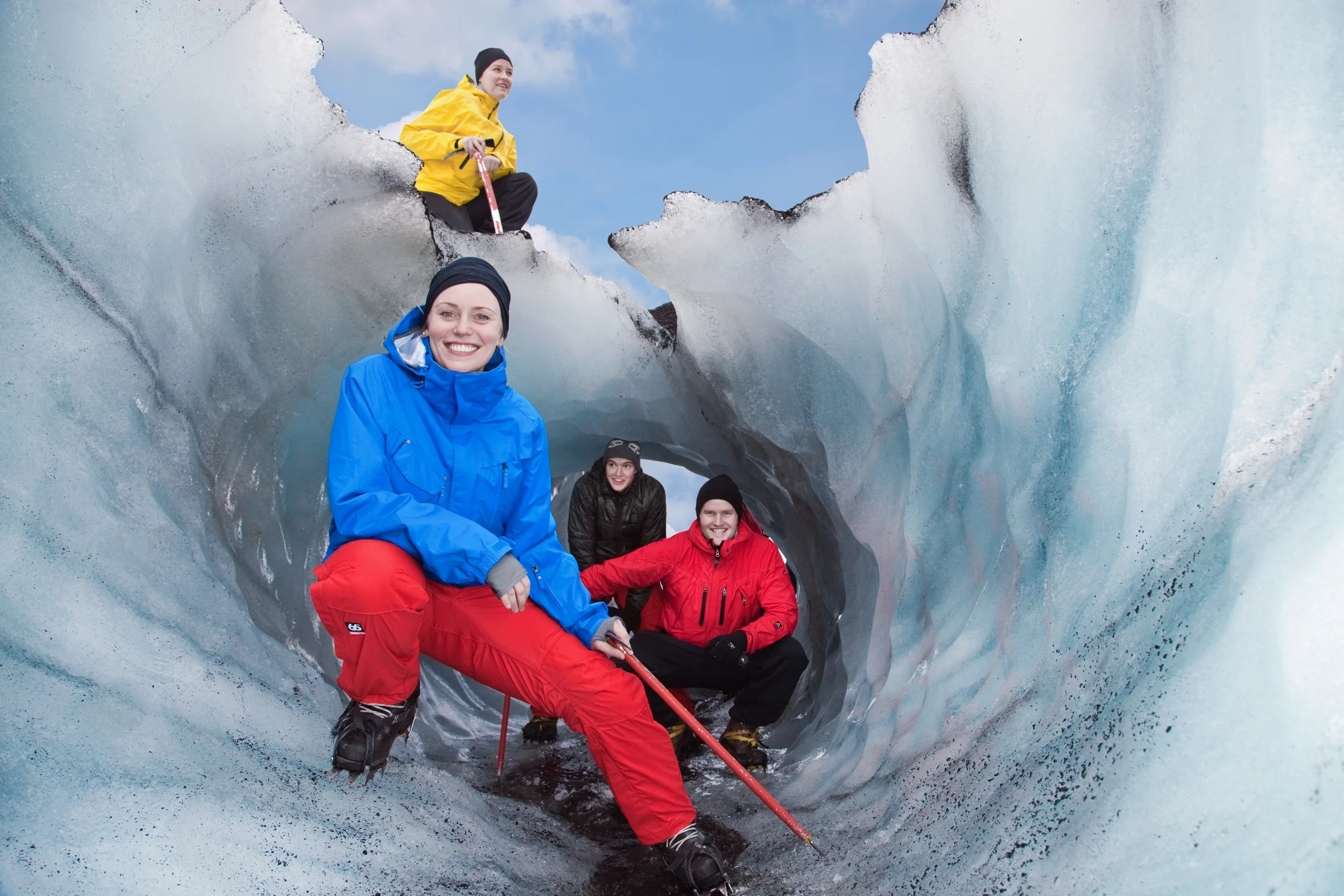 4 Personen bei einer Gletscherwanderung, ducken sich unter einen tieferen Abschnitt