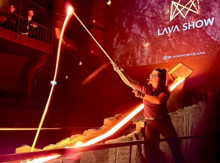 Frau, die Lava an einem langen Stab hält, bei einer Lava Show in Island