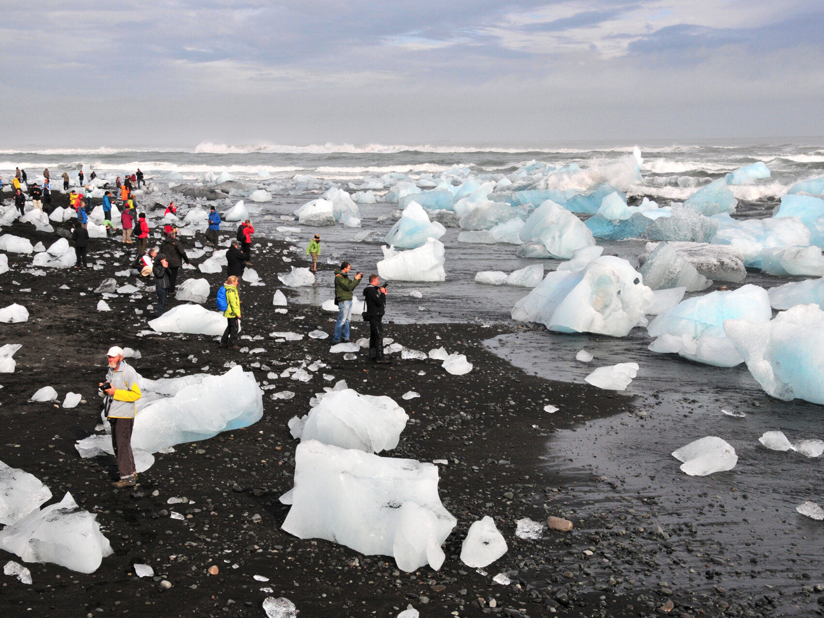 Eisberge am Abfluss des Jökulsarlon, Foto: Horst Müller
zeigt den schwarzen Strand, an dem große Eisberge angeströmt werden und Touristen, die sich diese anschauen