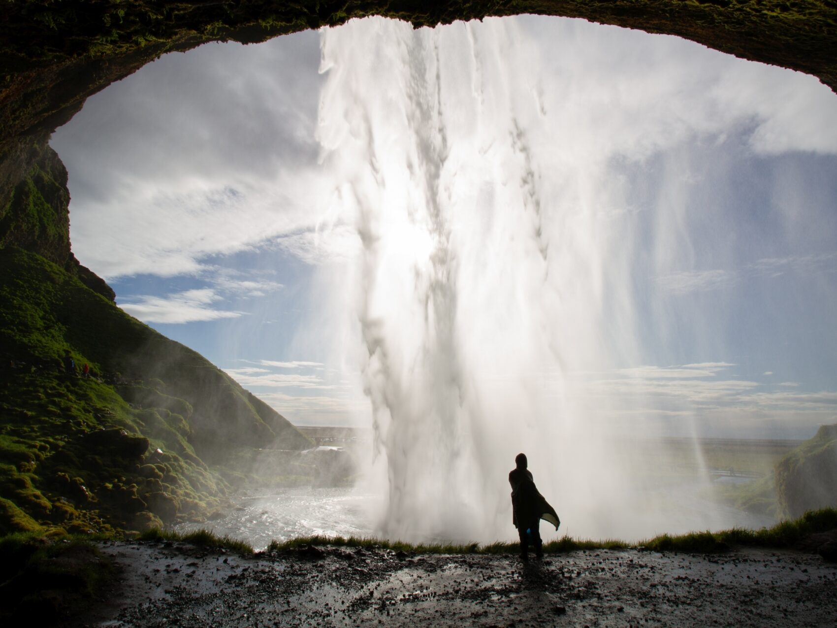 Hinter dem Wasserfall Seljalandsfoss, Foto: Erwin Bücherl
Person im Regencap steht hinter dem Wasserfall, den von vorne die Sonne anleuchtet