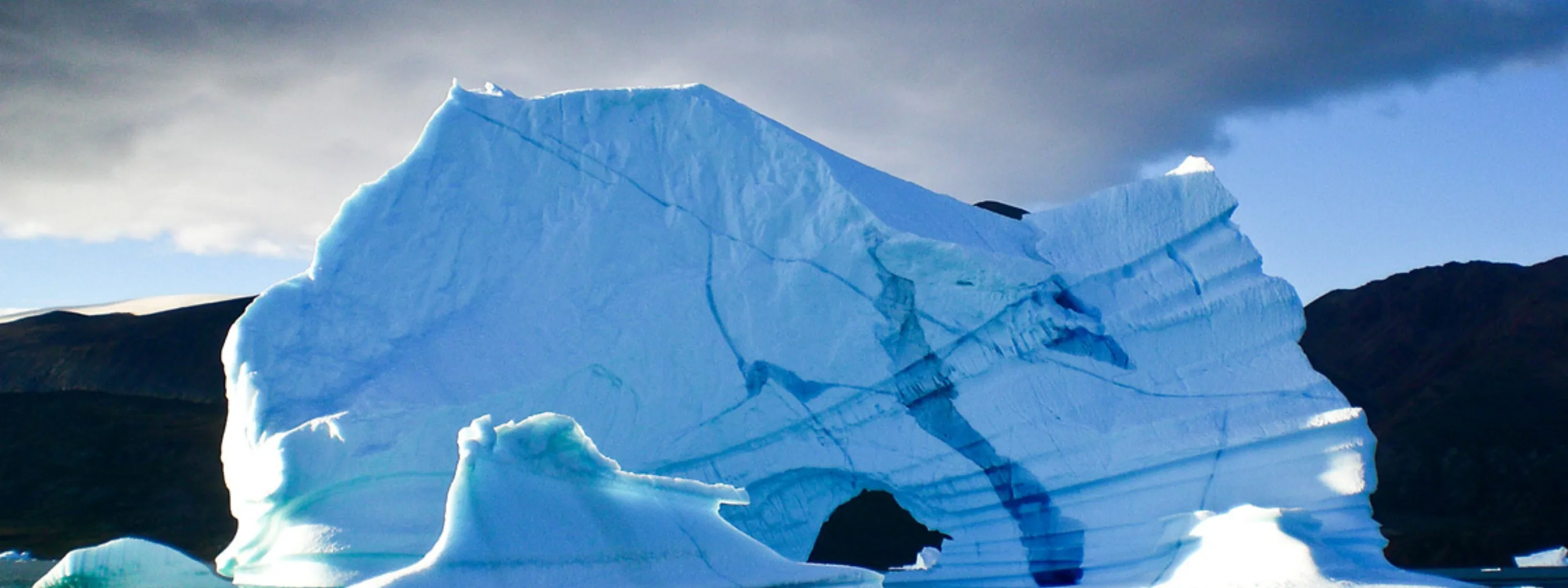 Eisberg Ostgrönland
imposanter Eisberg mit Lücke  am Meer. bewölkt