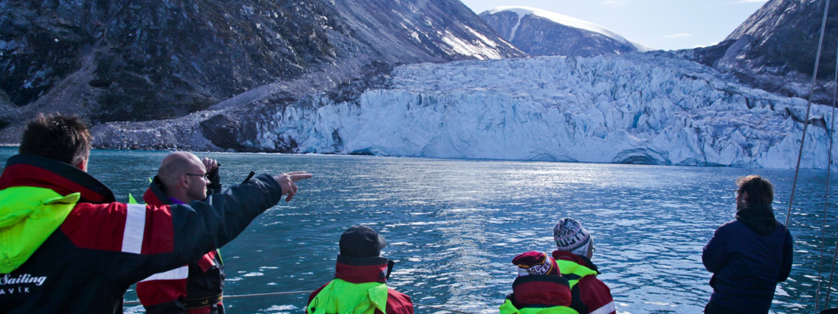 Segeltour Ostgrönland;
Besucher bestaunen vom Boot aus den ins Meer fließenden Gletscher