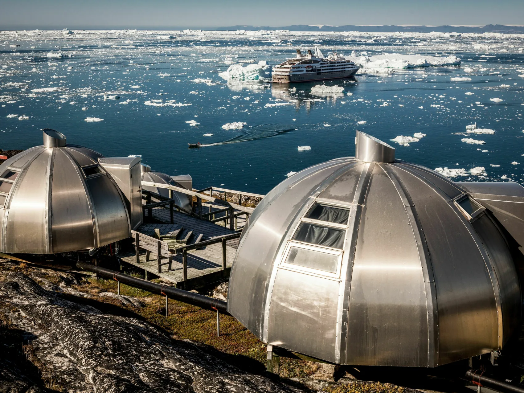 Iglo Hotels in Ilulissat im Hintergrund ein Schiff im Eismeer