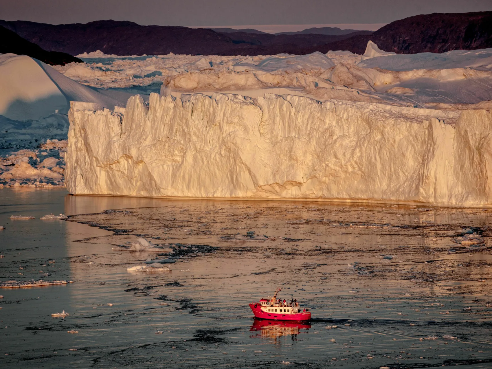 Nordgrönland: Eisfjord Ilulissat
Passagierboot fährt bei Sonnenuntergang durch den Eisfjord