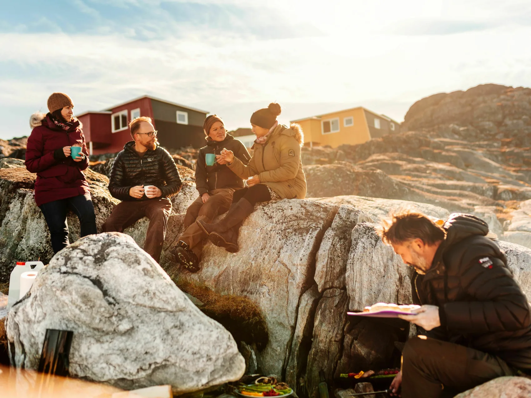 Reisegruppe picknikt im Sonnenschein am felsigen Strand