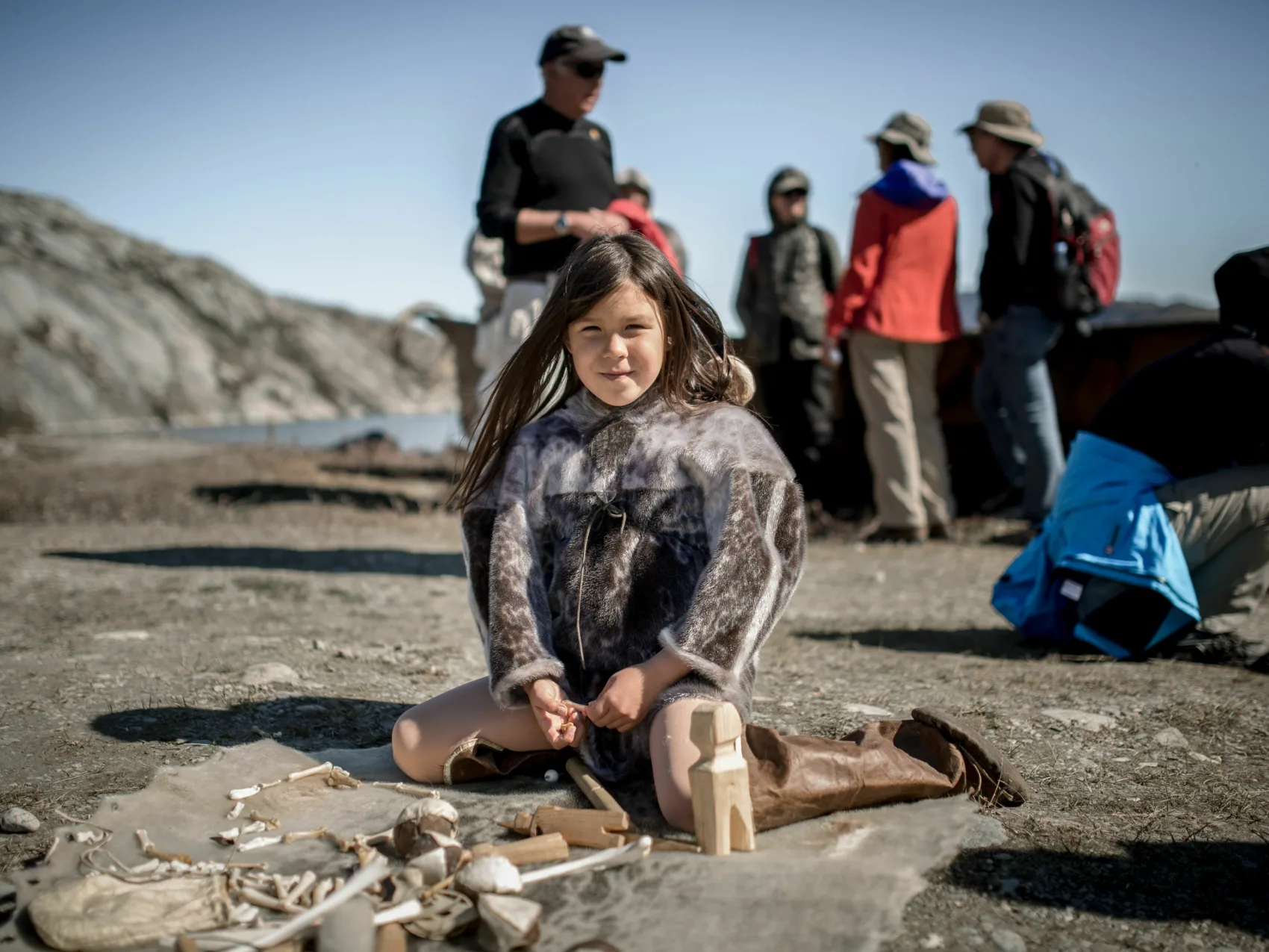 Nordgrönland: Mädchen spielt mit Holzfiguren in Qasigiannuit
