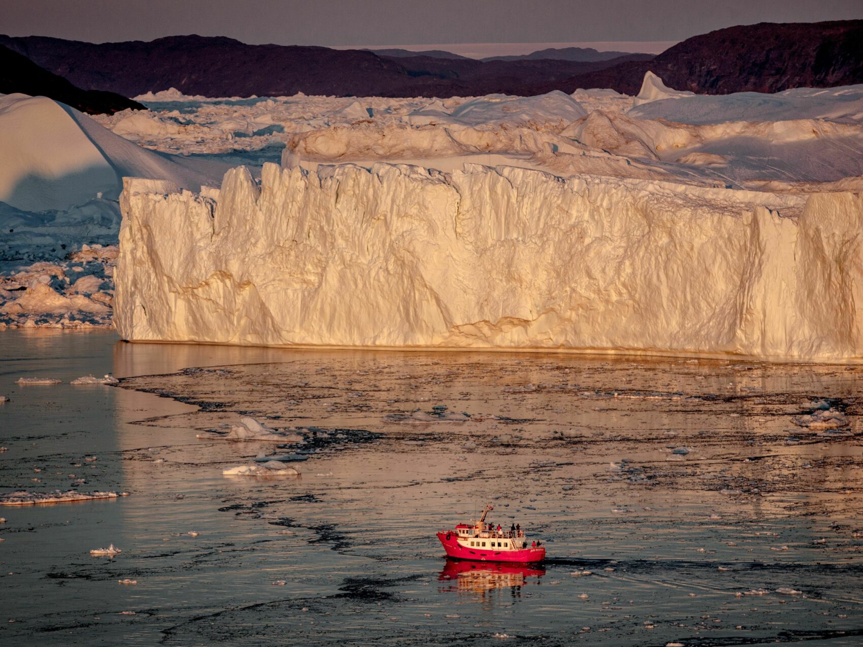 Nordgrönland: Eisfjord Ilulissat
Passagierboot fährt bei Sonnenuntergang durch den Eisfjord