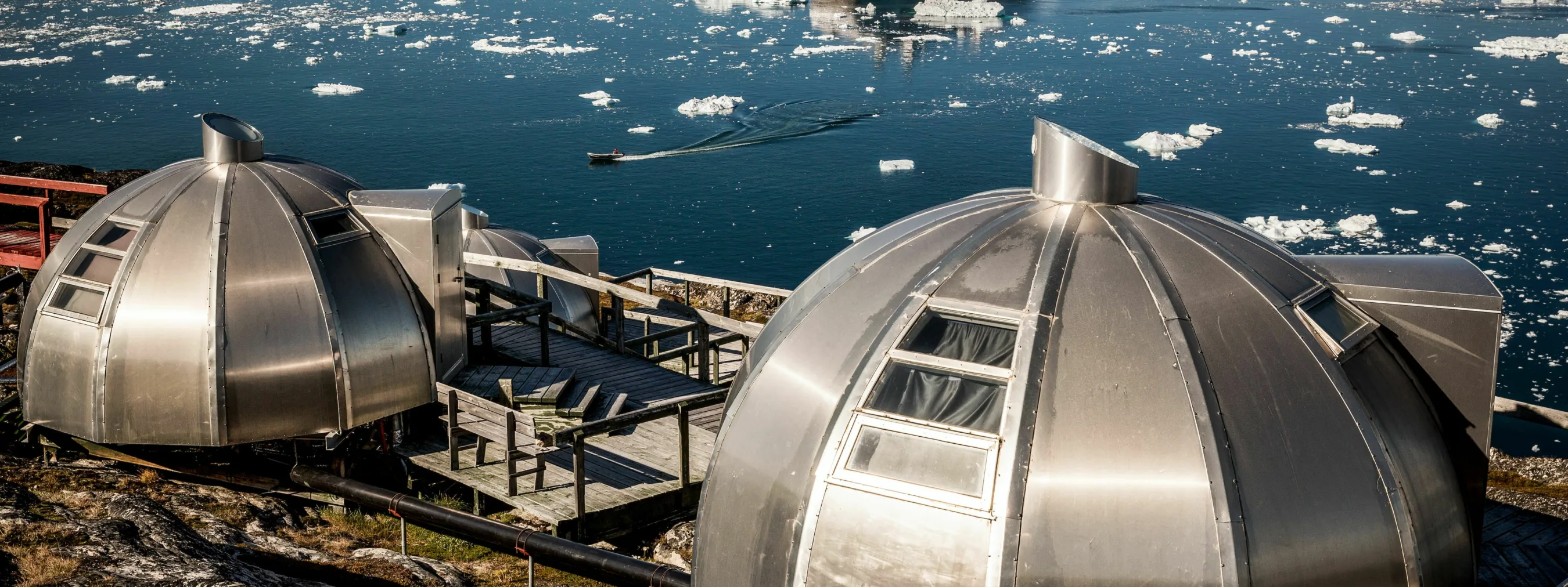 Iglo Hotels in Ilulissat im Hintergrund ein Schiff im Eismeer