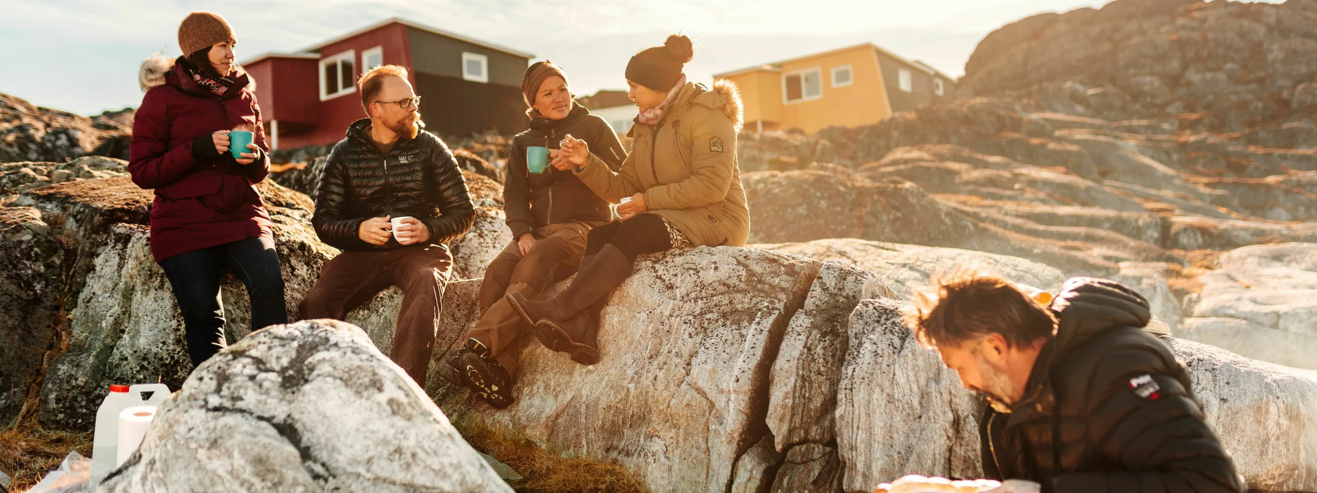 Reisegruppe picknikt im Sonnenschein am felsigen Strand