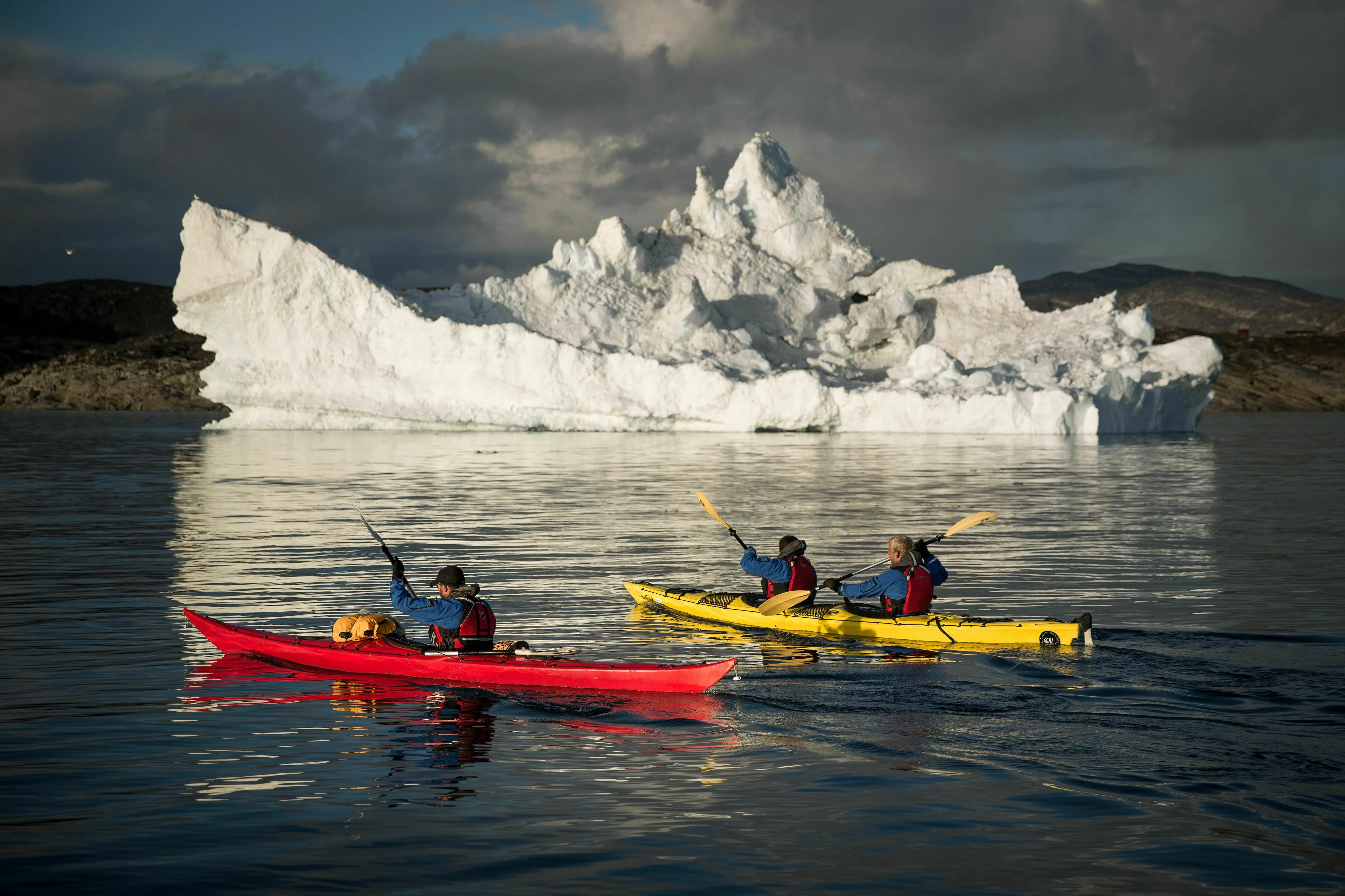 Eisberge im Fjord mit zwei Kajaks im Vordergrund
