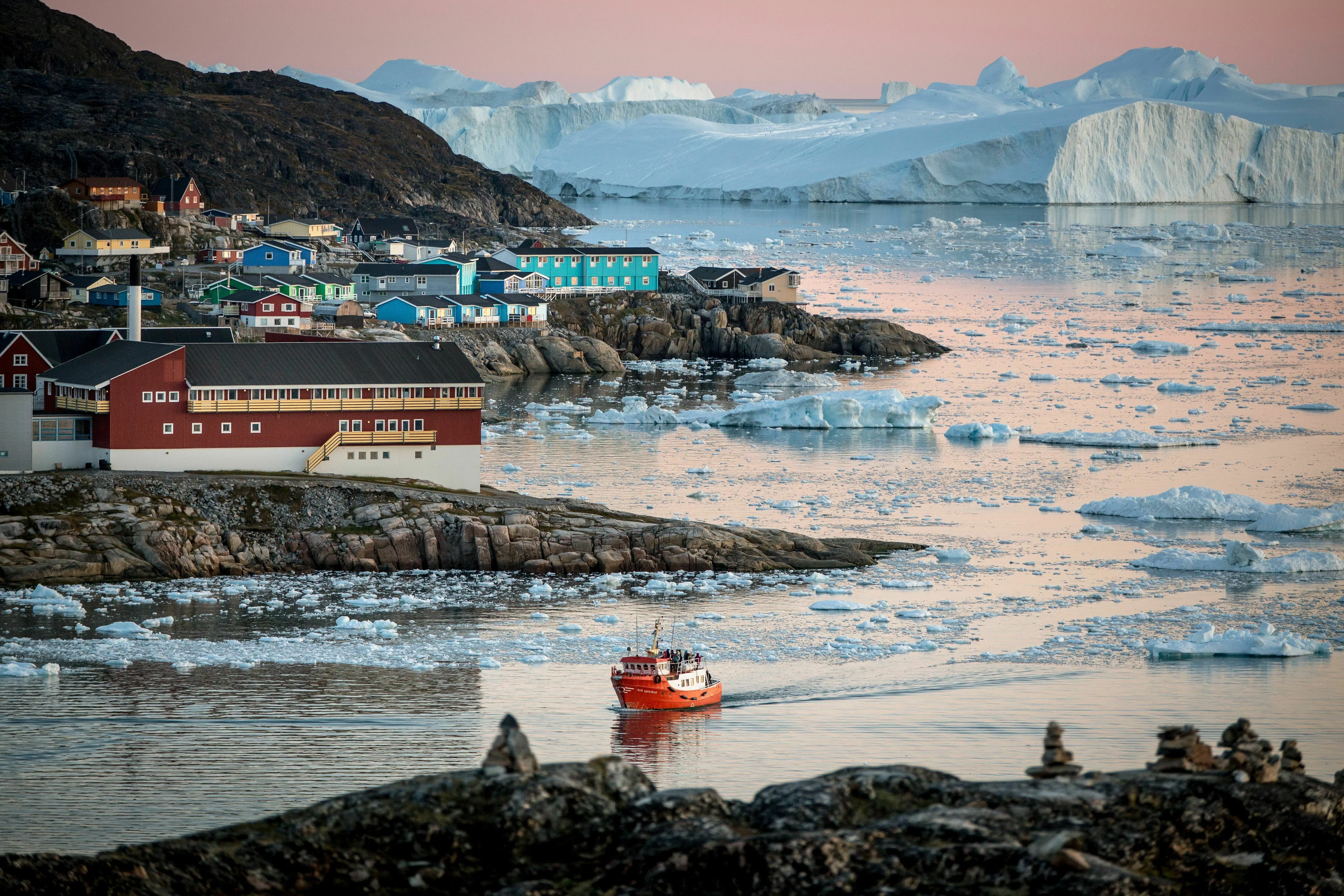 Nordgrönland: Hafen Ilulissat; 
kleines Schiff fährt im Hafen ein, im Hintergrund Eisberge