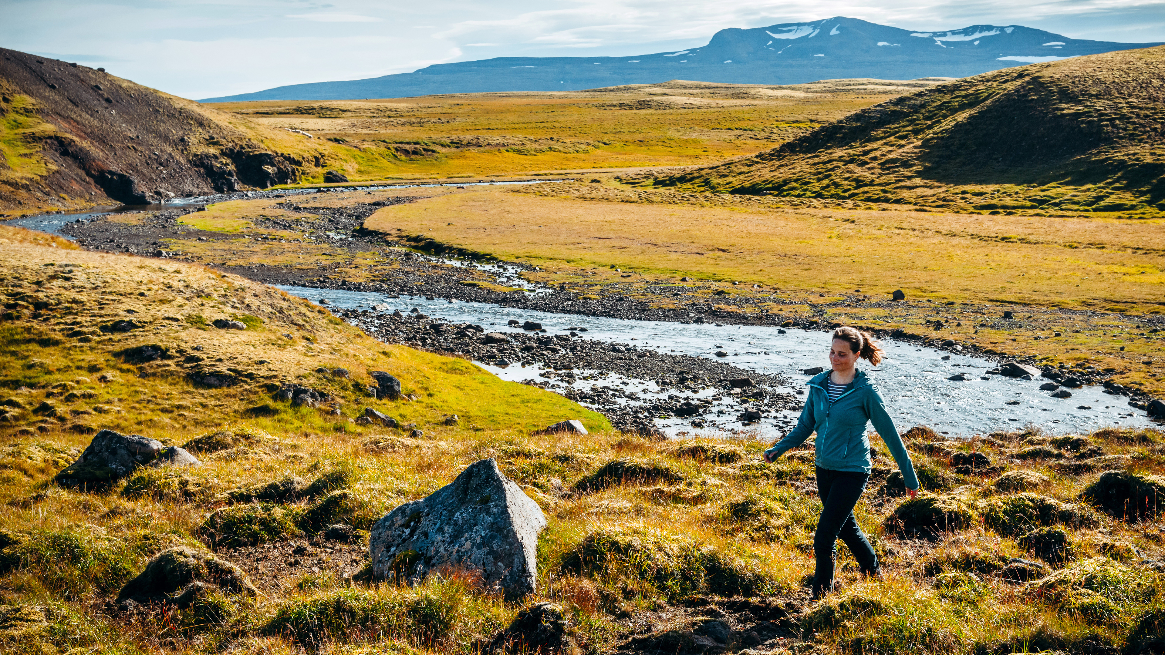 Frau wandert am Fluss in Island