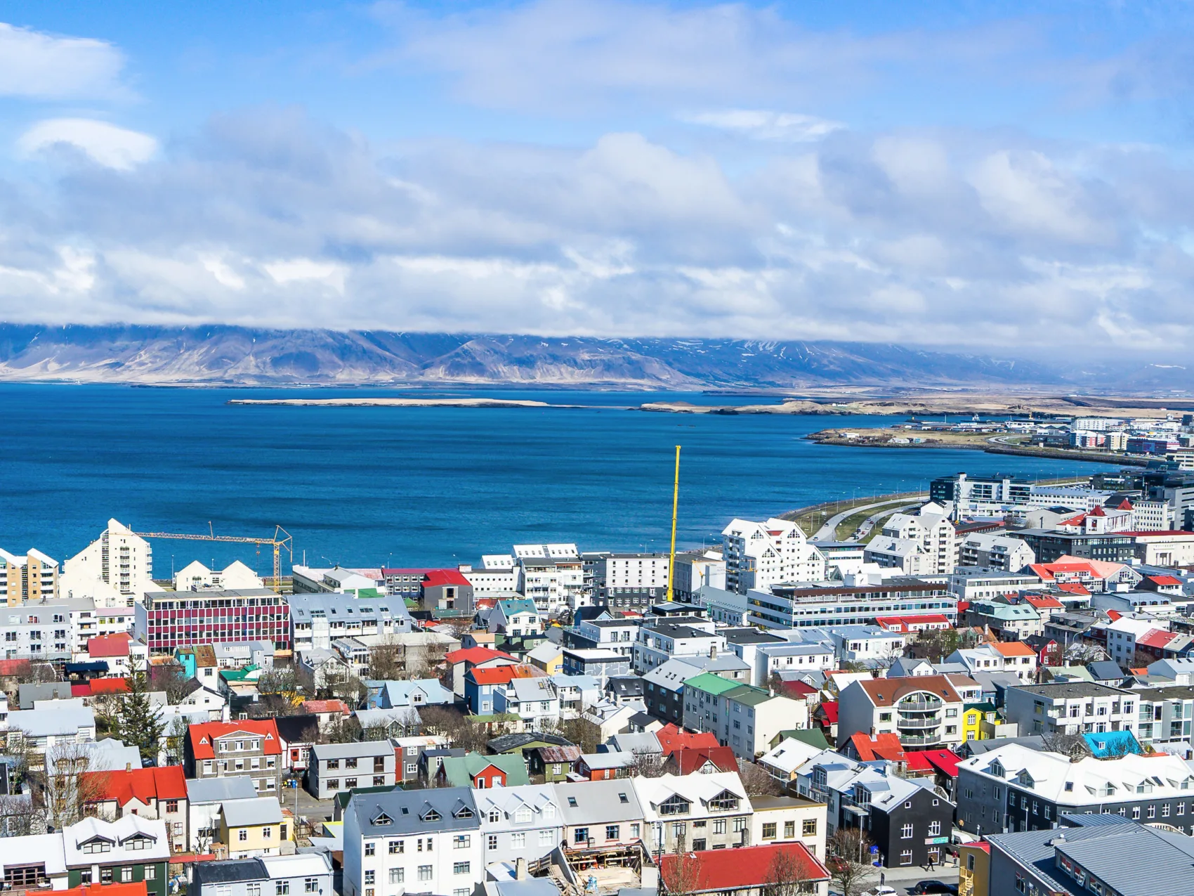 Luftaufnahme der isländischen Hauptstadt Reykjavik mit Meer und Bergen im Hintergrund