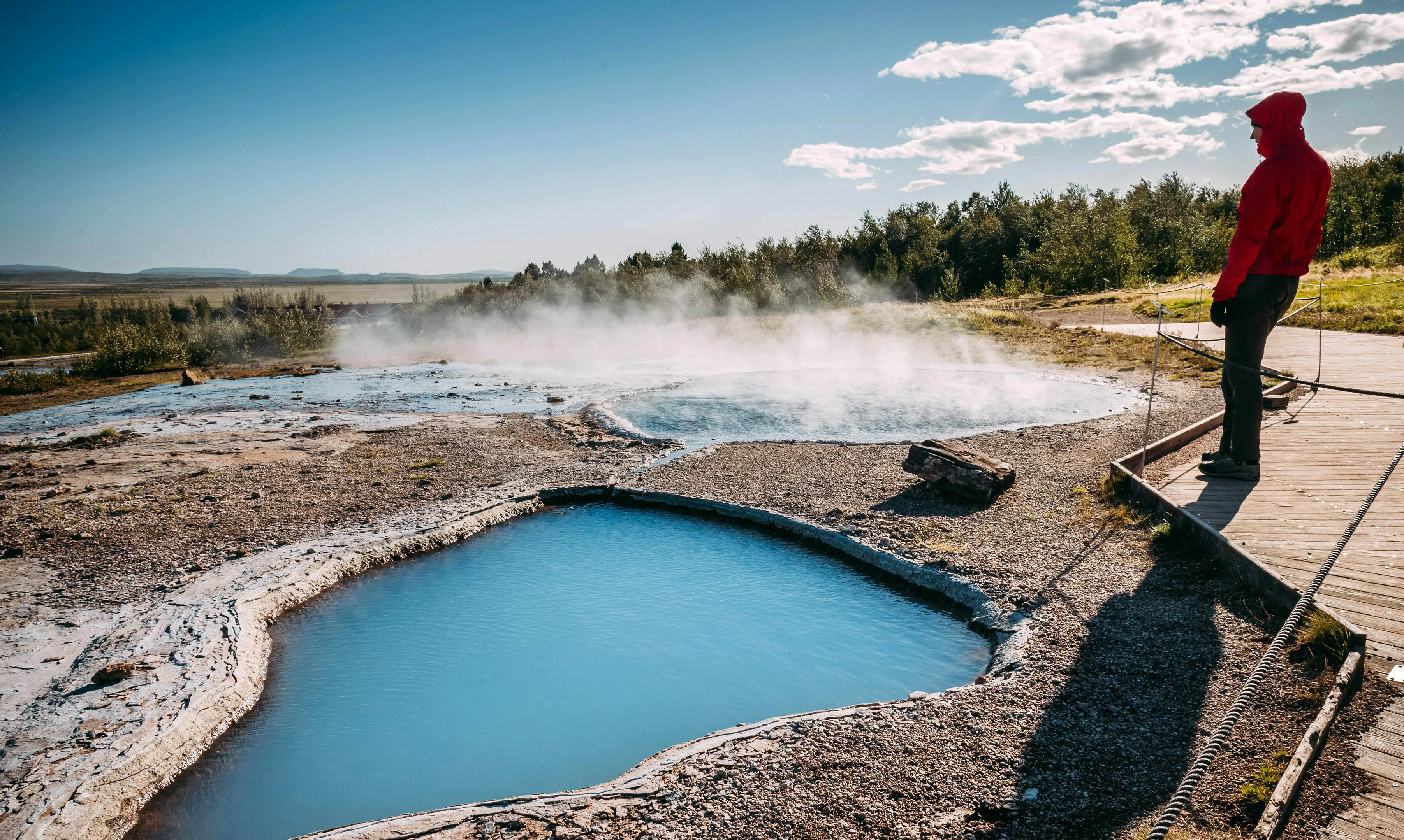 Reisender steht am Geysir in Island