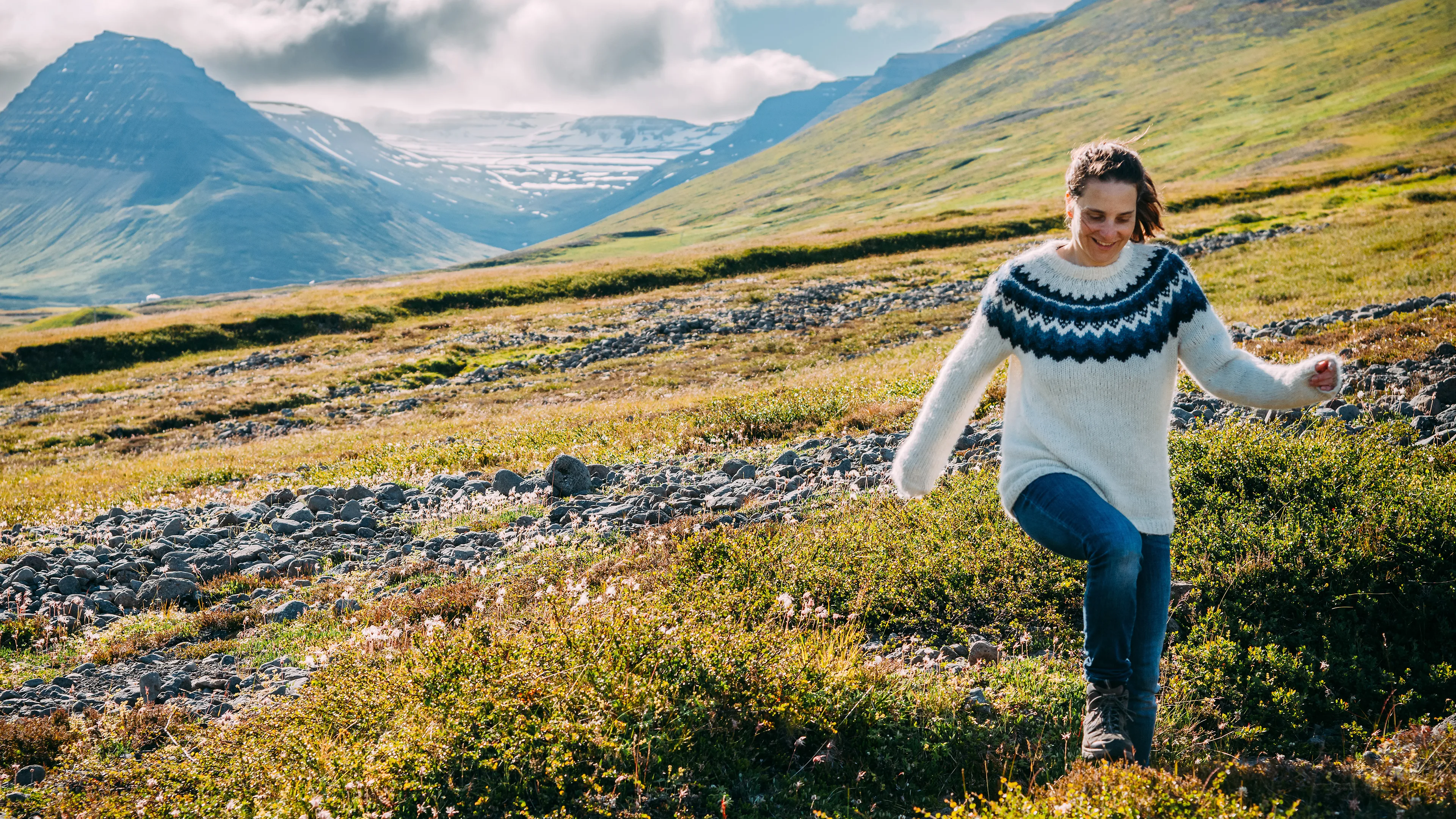 Frau mit Islandpullover wandert in der Landschaft Islands