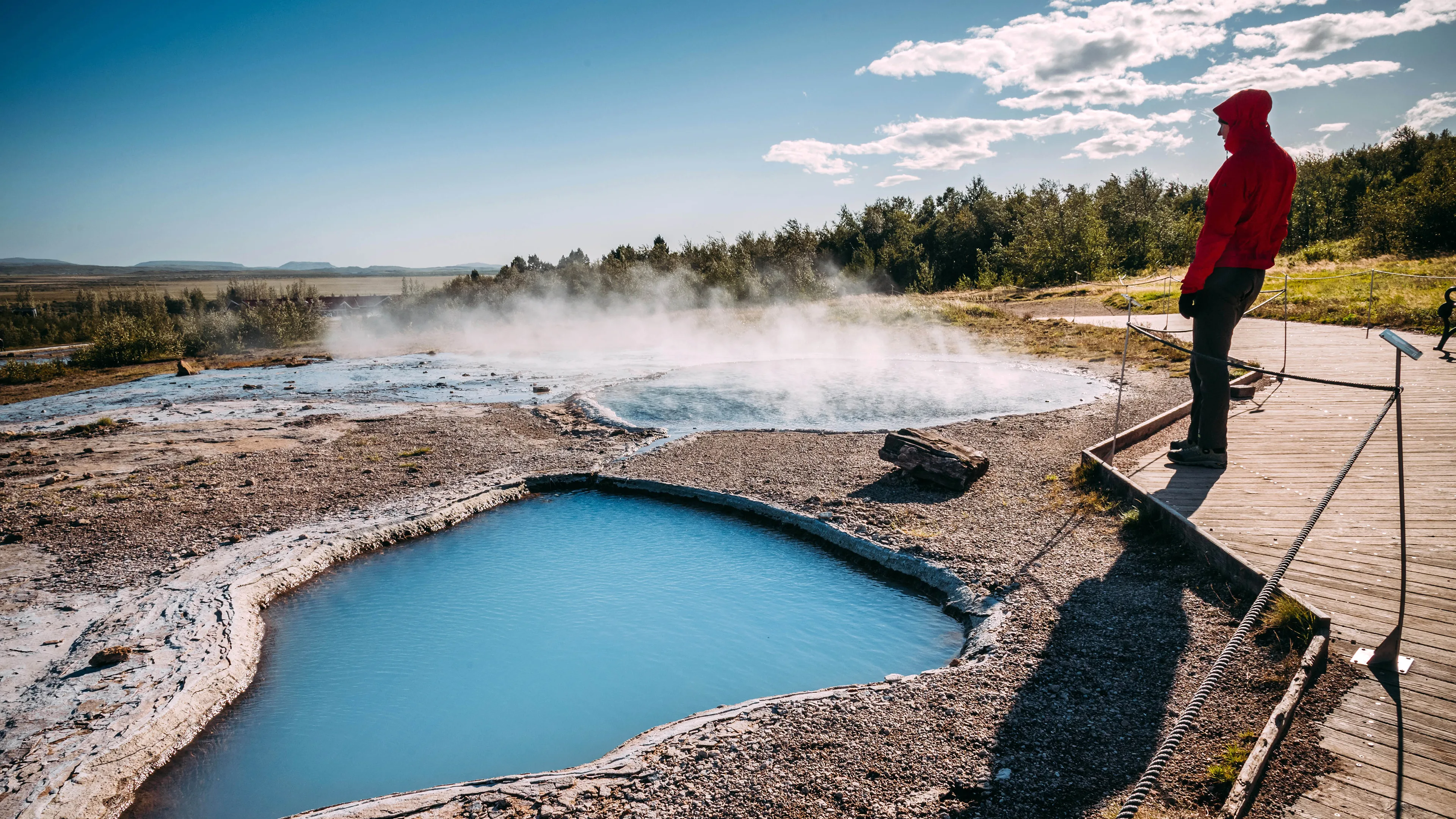 Reisender steht am Geysir in Island