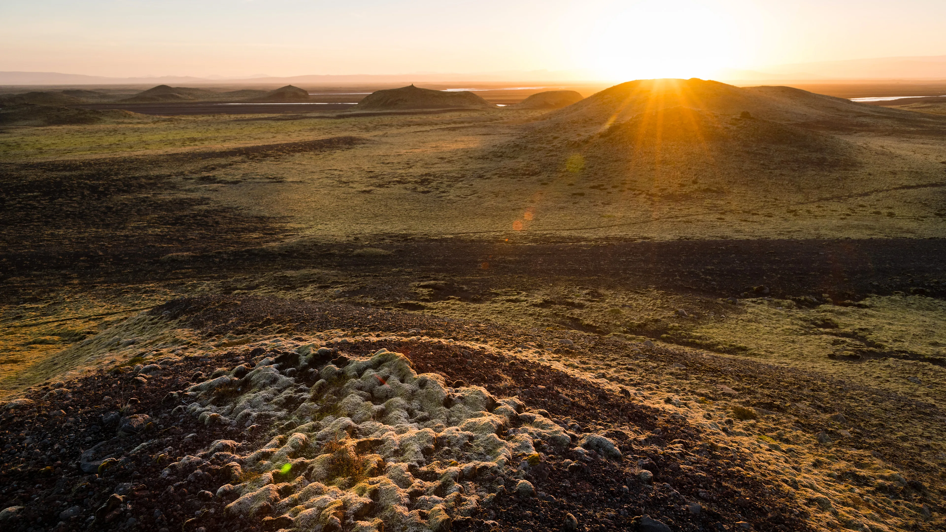 Weite moose Landschaft mit einigen kleinen Hügeln bei Sonnenuntergang