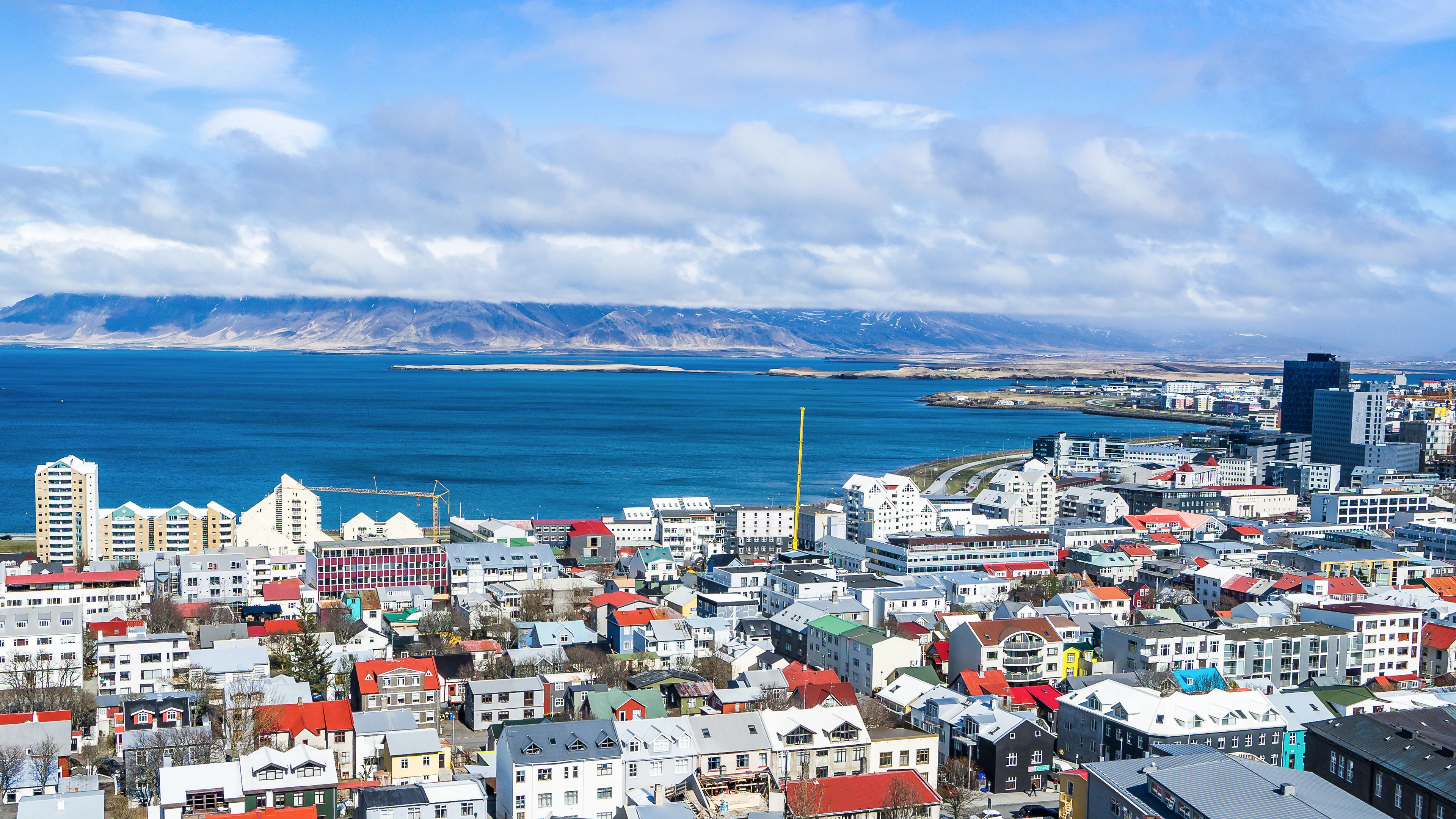 Luftaufnahme der isländischen Hauptstadt Reykjavik mit Meer und Bergen im Hintergrund