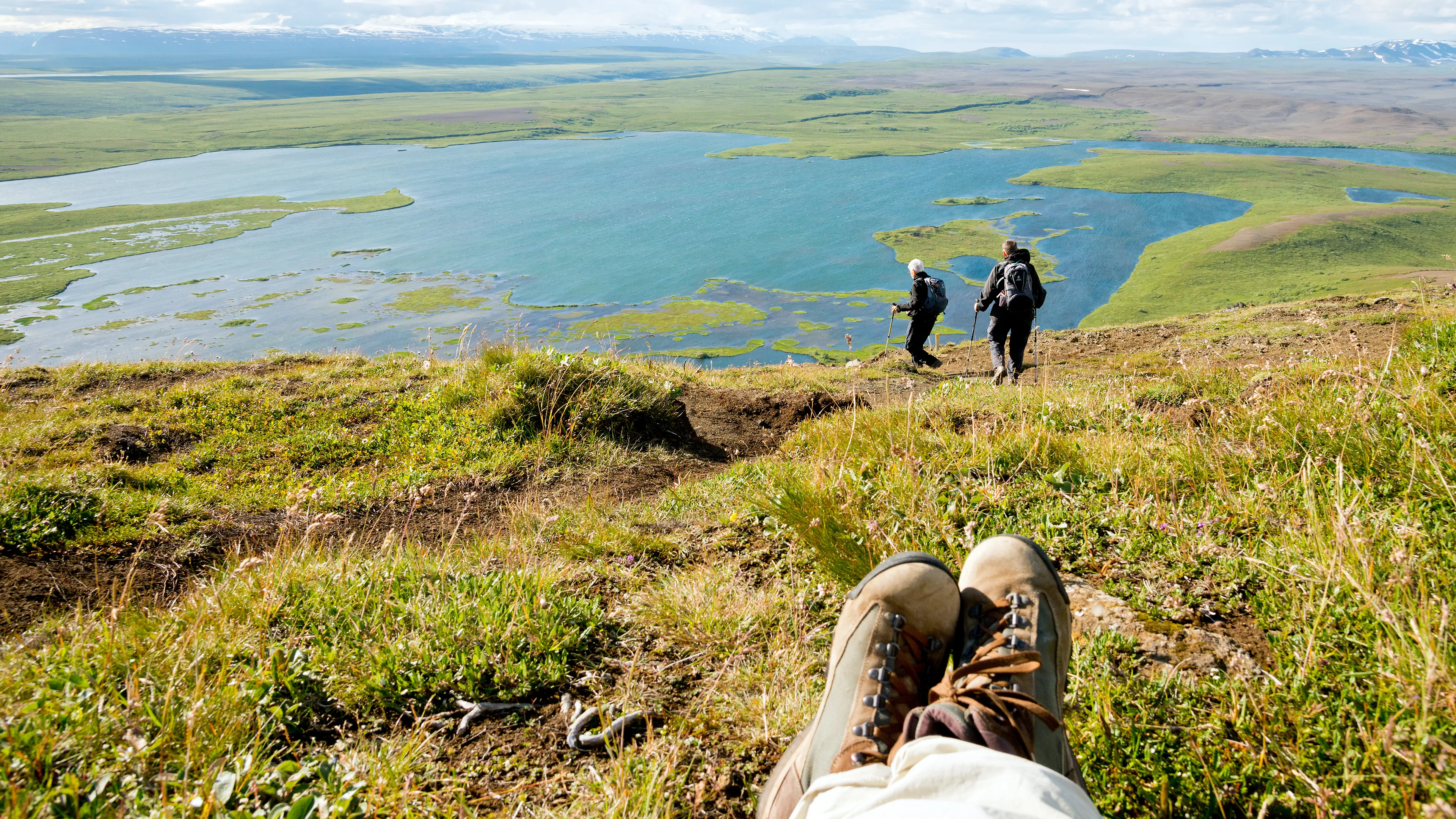 Kleine Wandergruppe wandert an einem schönen See in Island entlang