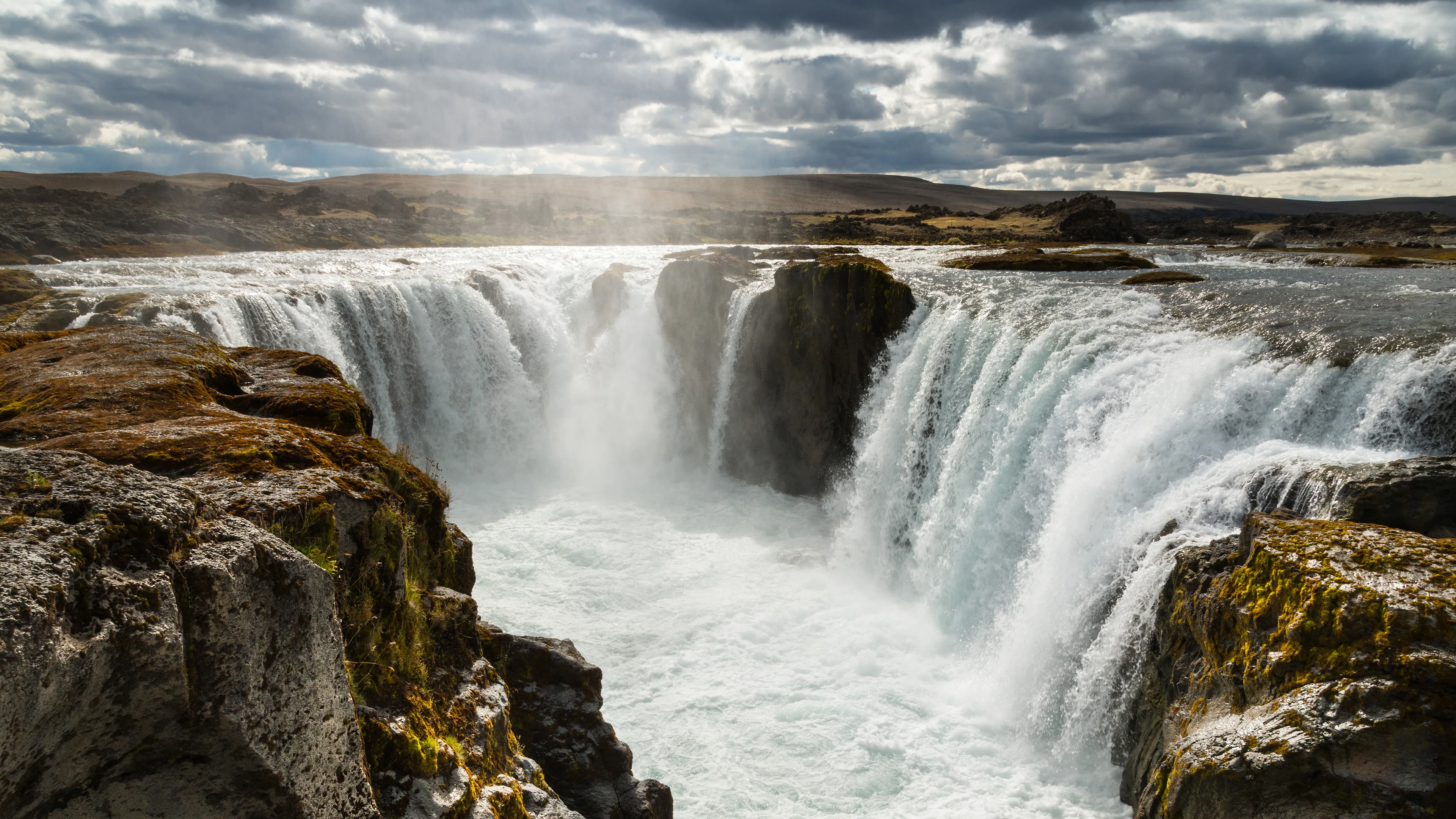 Der Wunderschöne Goðafoss Wasserfall in Island, in bewölktem Wetter mit einigen Sonnenstrahlen die hindurchschienen