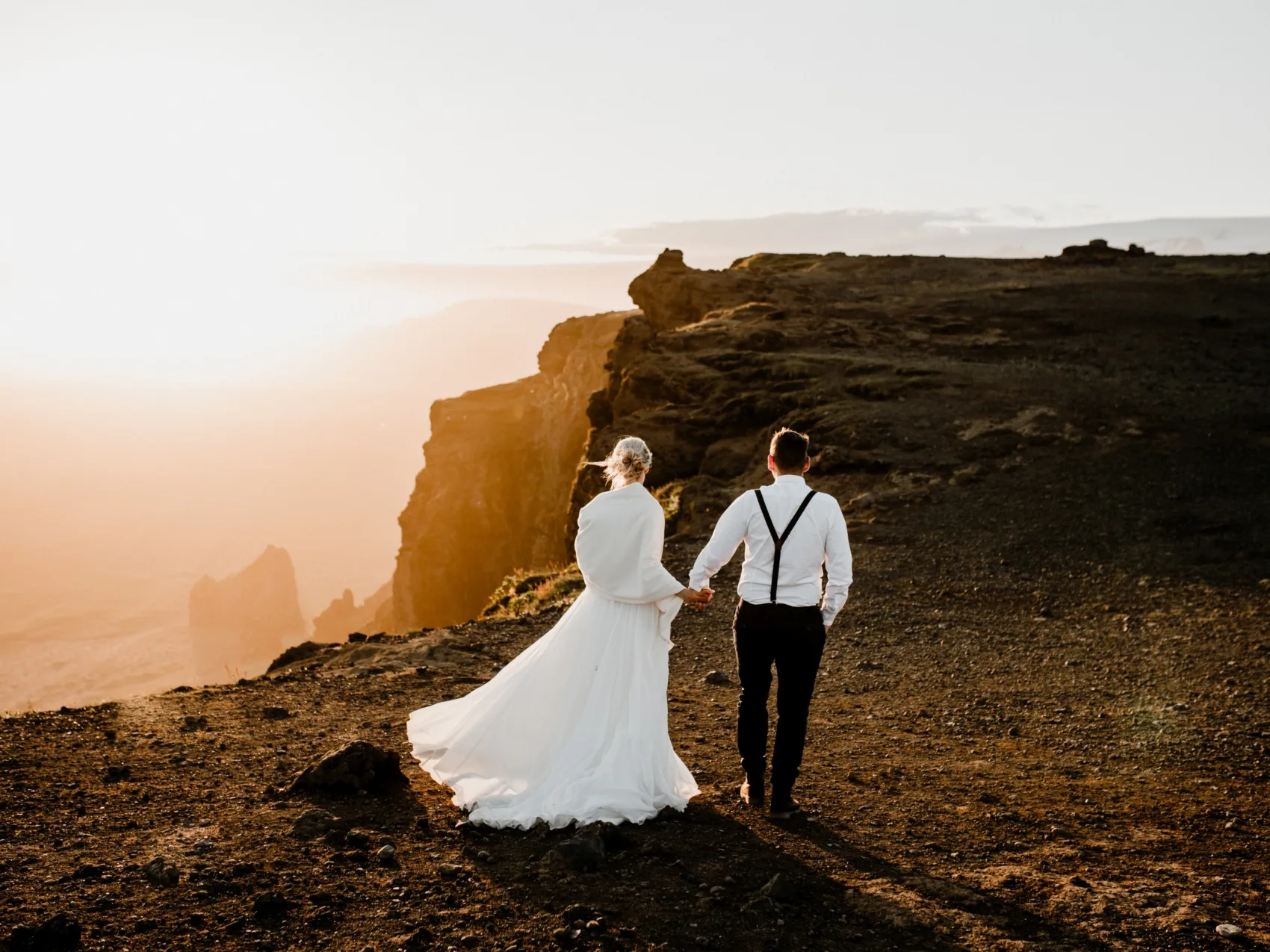 Heiraten in Island mit Katla Travel, Pärchen im Sonnenuntergang oben auf einem Berg