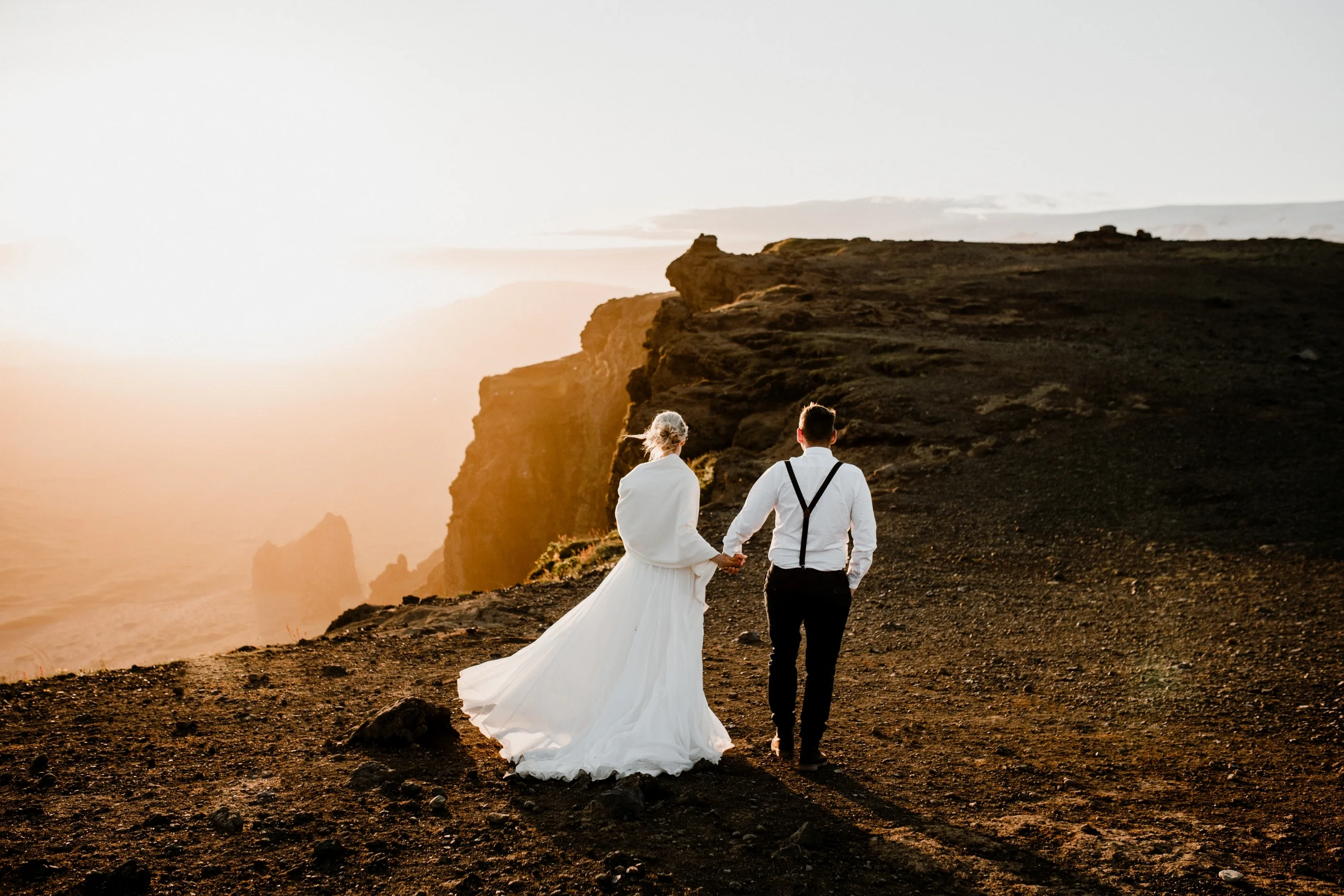 Heiraten in Island mit Katla Travel, Pärchen im Sonnenuntergang oben auf einem Berg