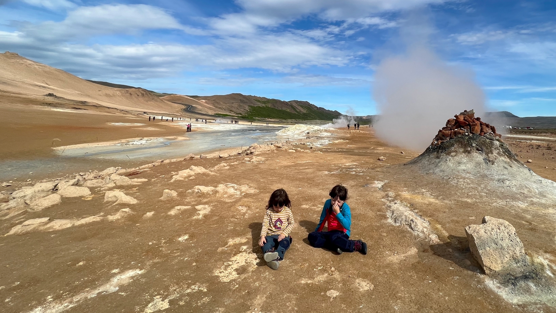 Kinder sitzen bei den Fumarolen von Namafjall in Island