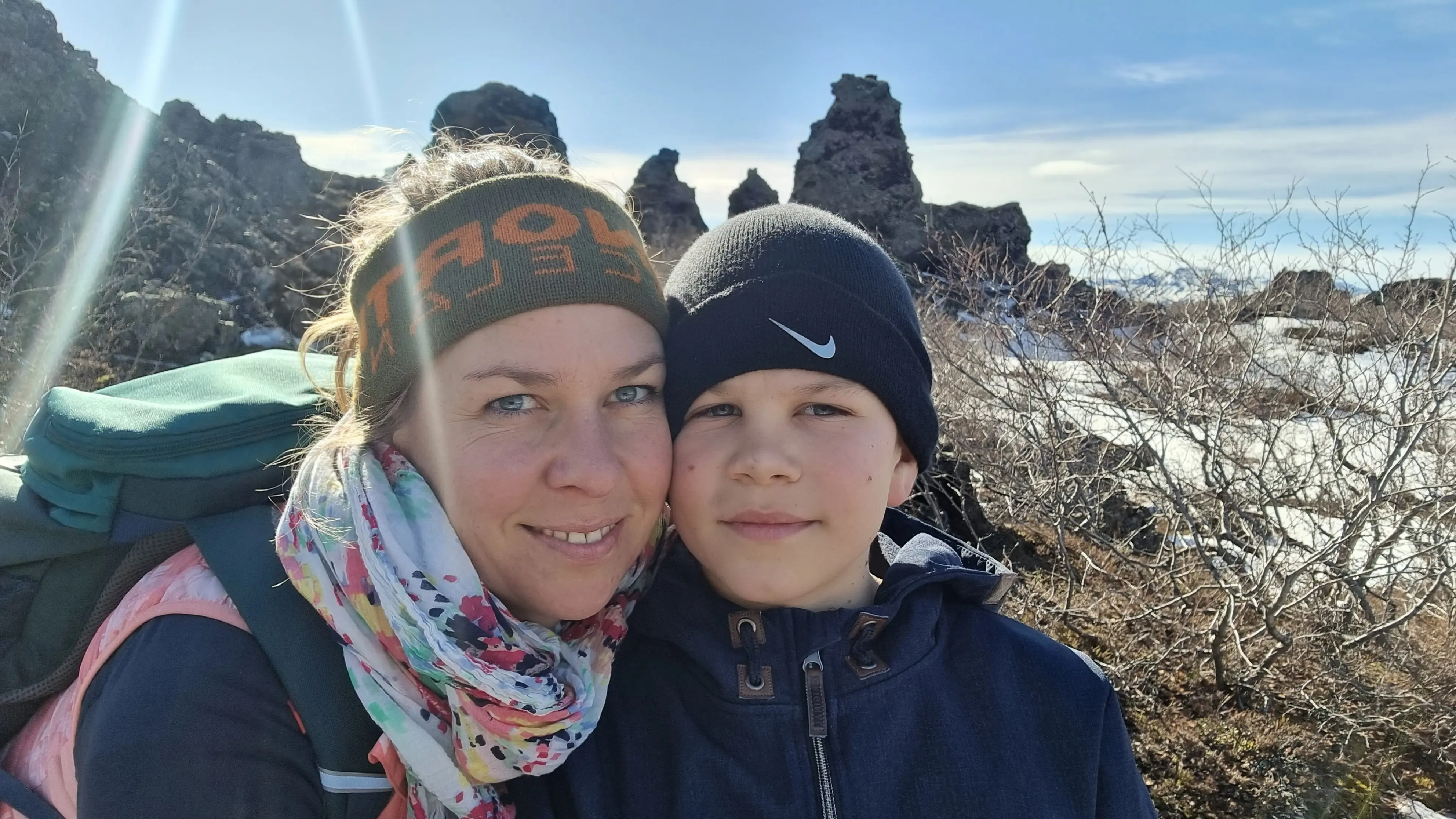 Katla Mitarbeiterin mit ihrem Kind in Island, im Hintergrund viele Felsen bei schönem Wetter