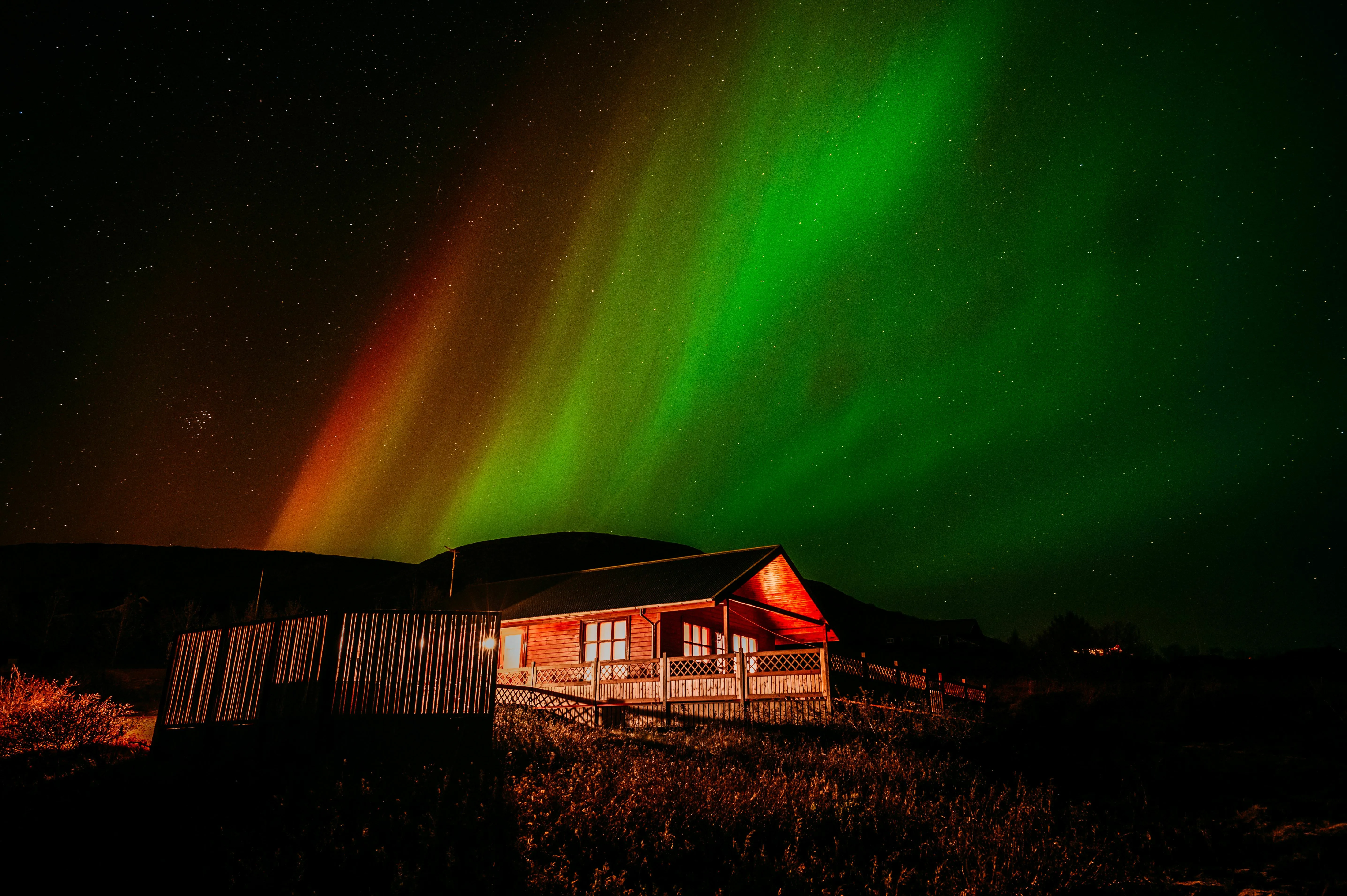 Nordlichter über dem Ferienhaus Oskasteinn, welches sich in Südisland befindet.