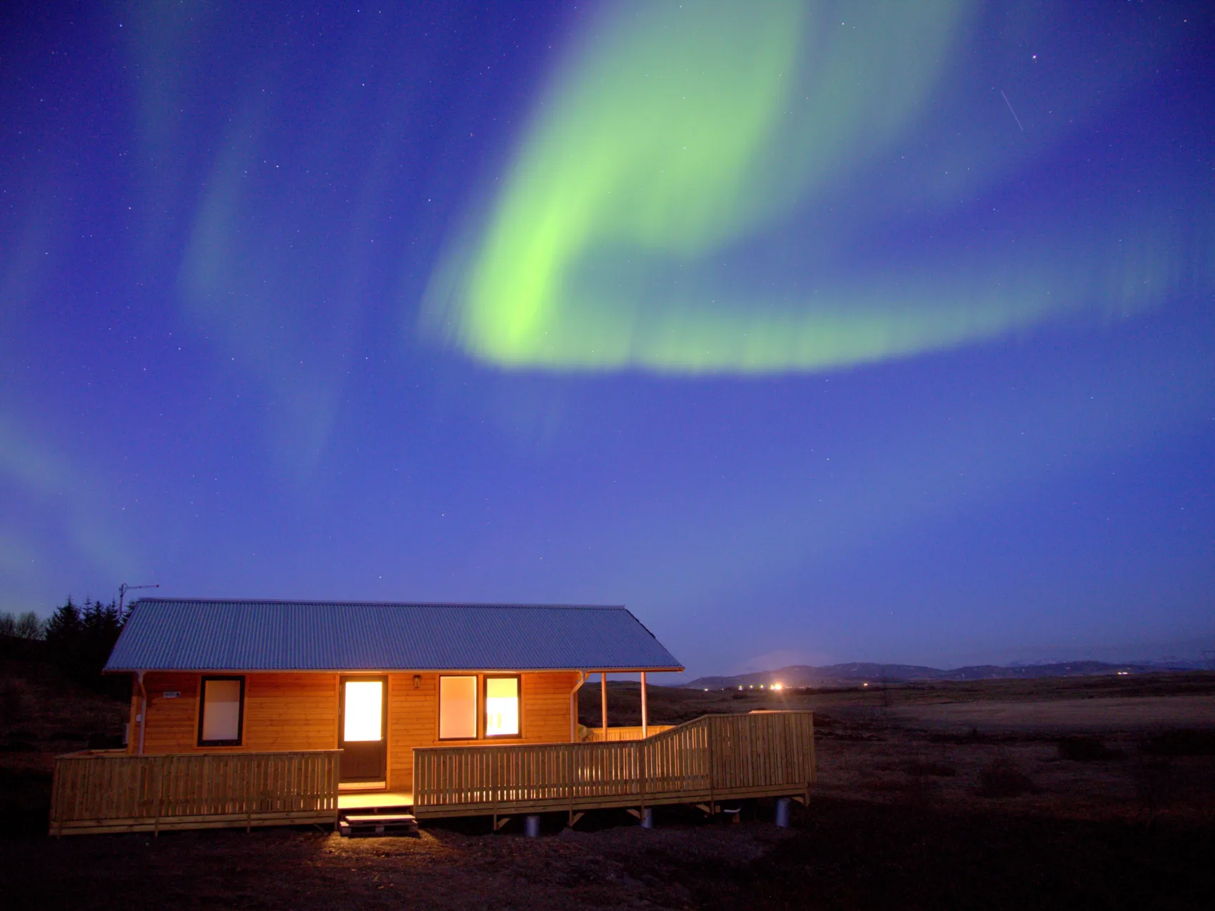 Nordlichter über einem Ferienhaus im Süden Islands im Winter