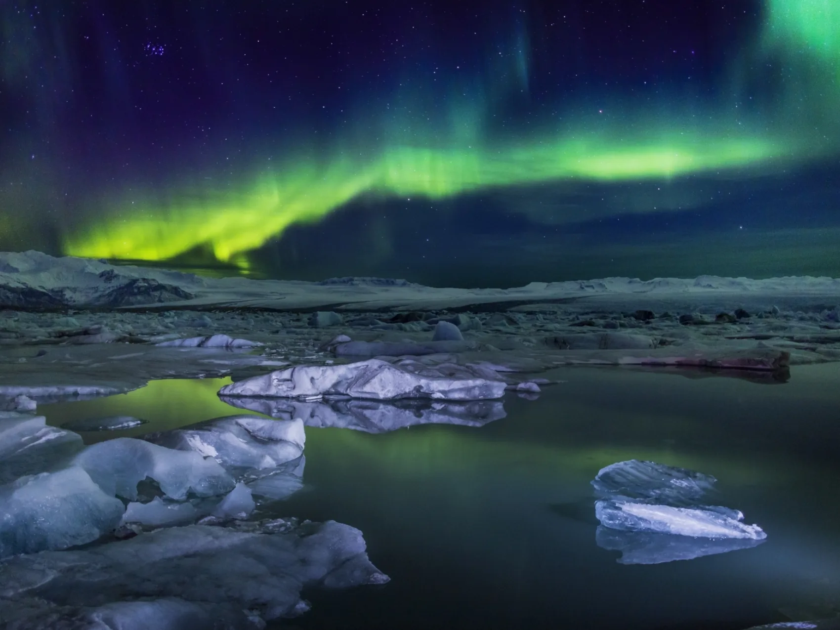 Eine Winternacht in Jökulsárlón, wo die Nordlichter den Himmel bedecken.