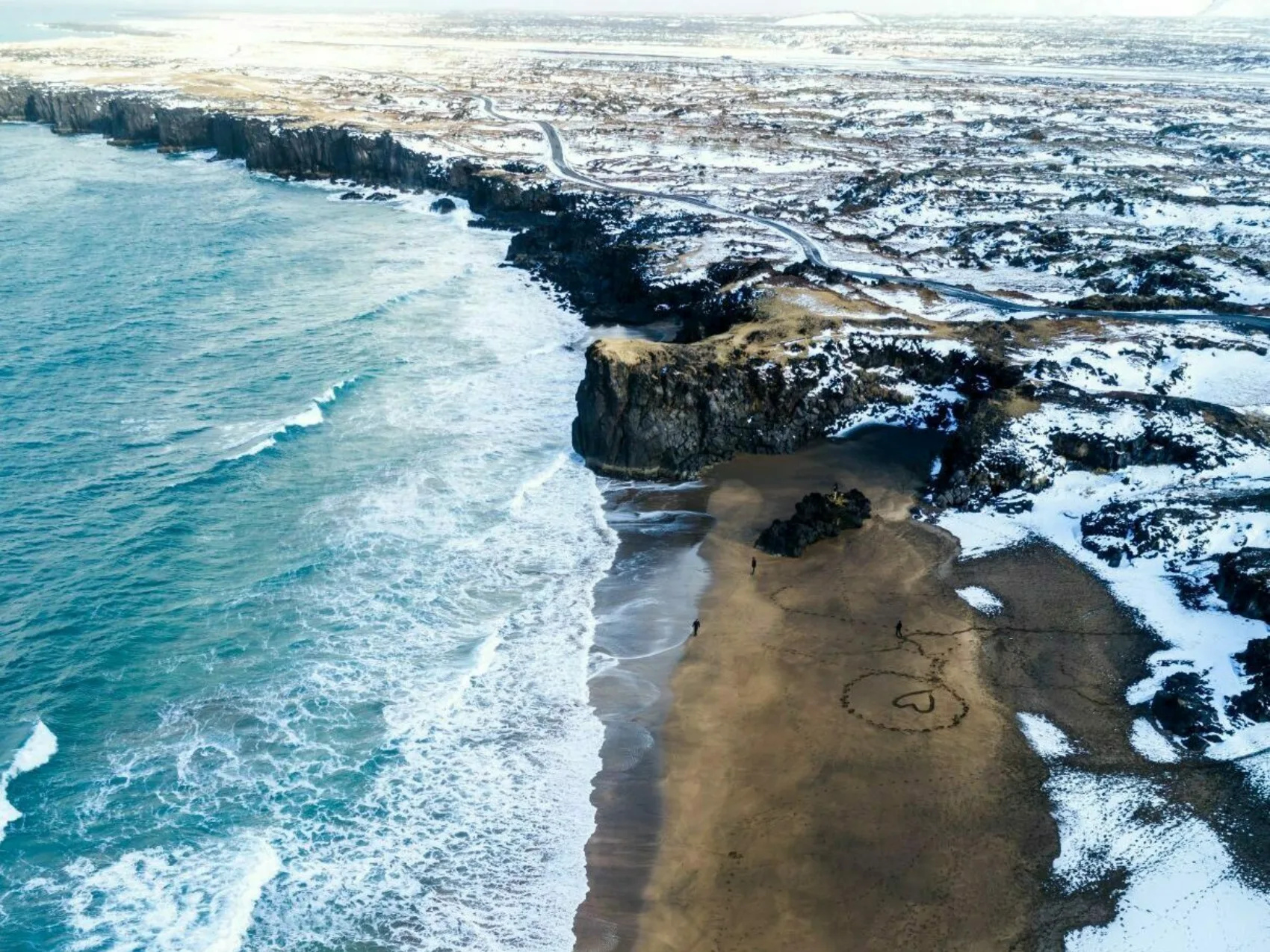Ein Strand im Westen Islands auf einem wunderschönen Winterteig, am Strand ist ein Herz in den Sand gezeichnet.