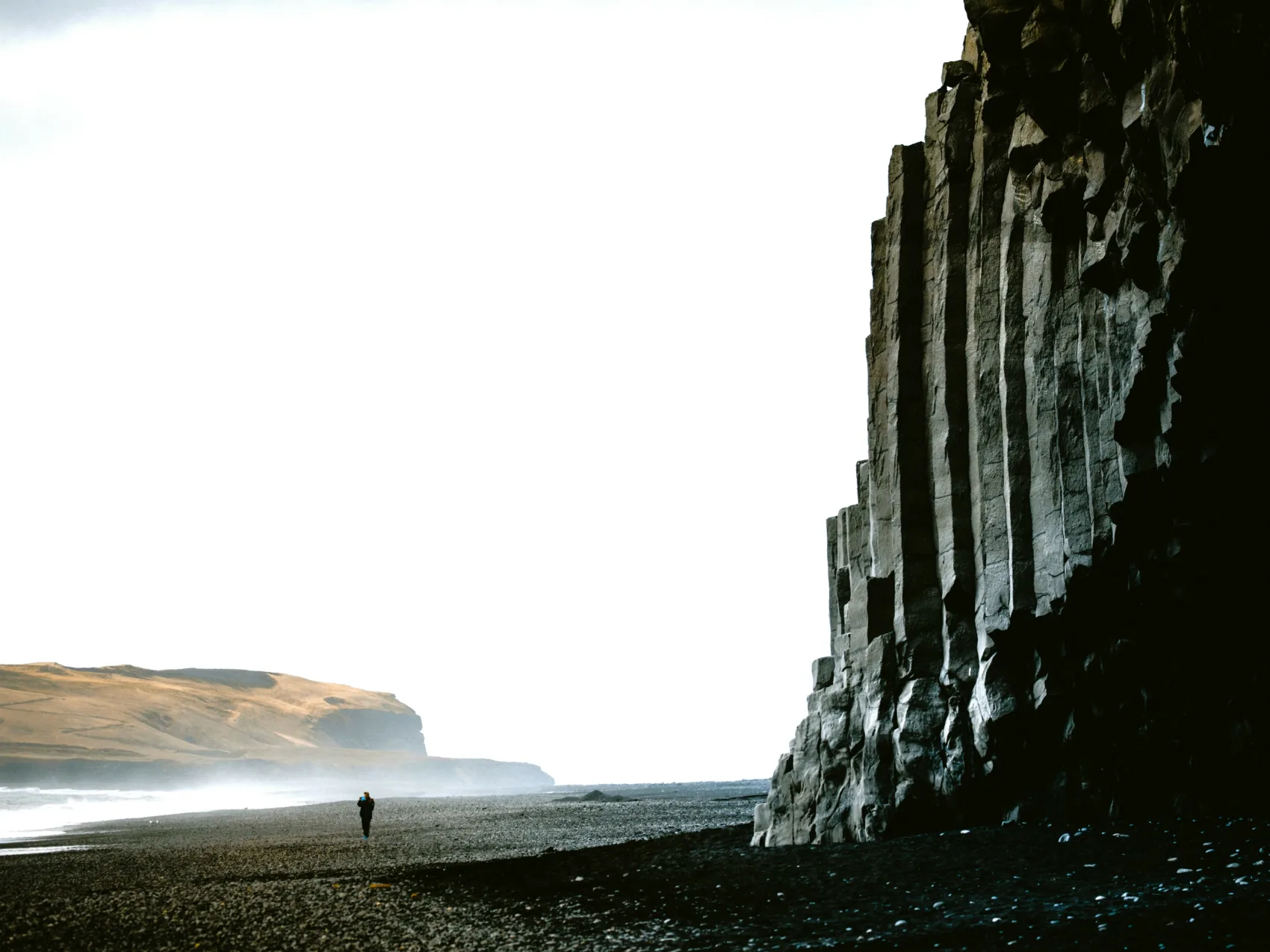 Reynisfjara, ein schwarzer Strand mit majestätischen Felsen und meer.