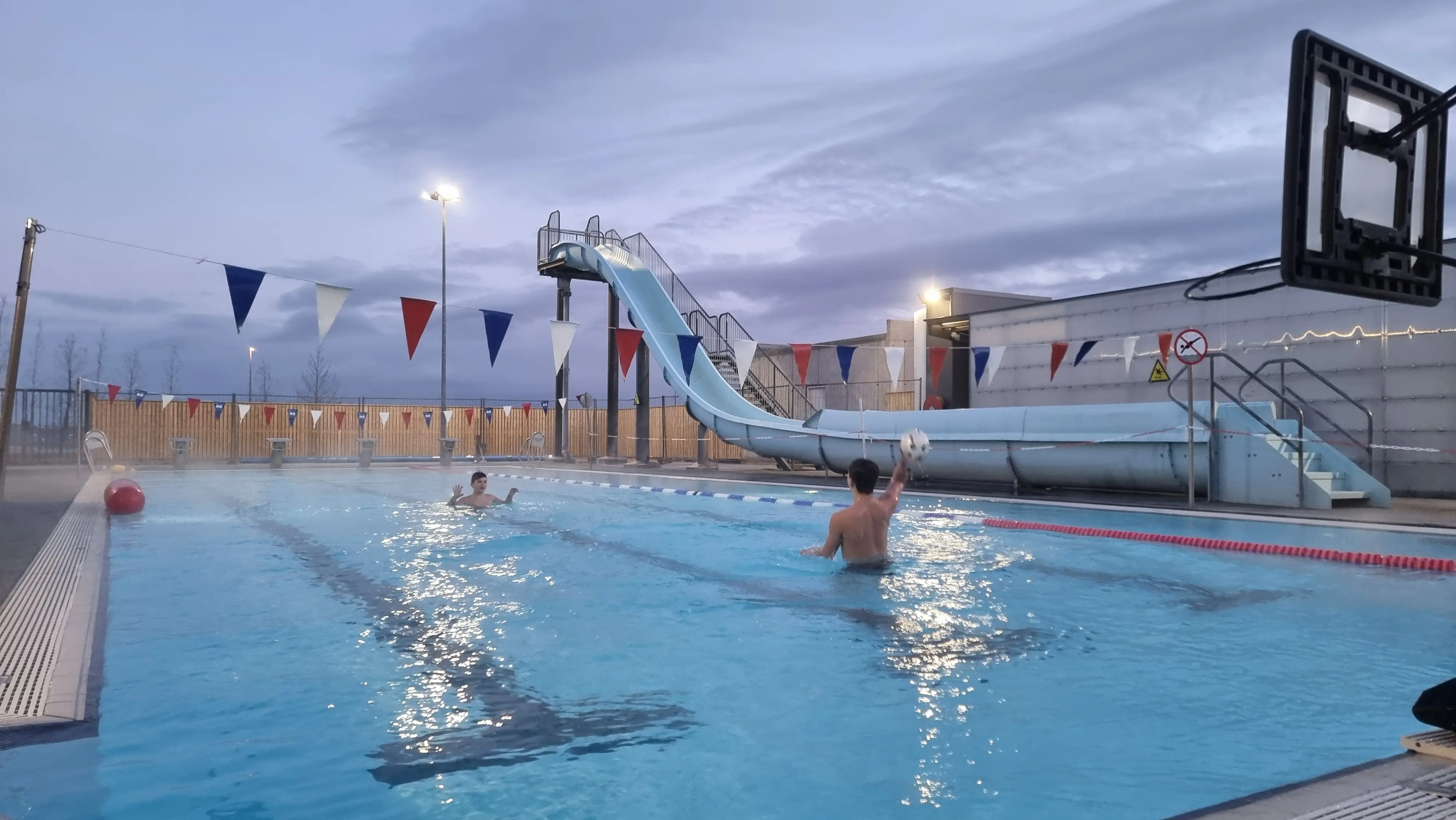Kinder beim Ballspiel im Freibad.