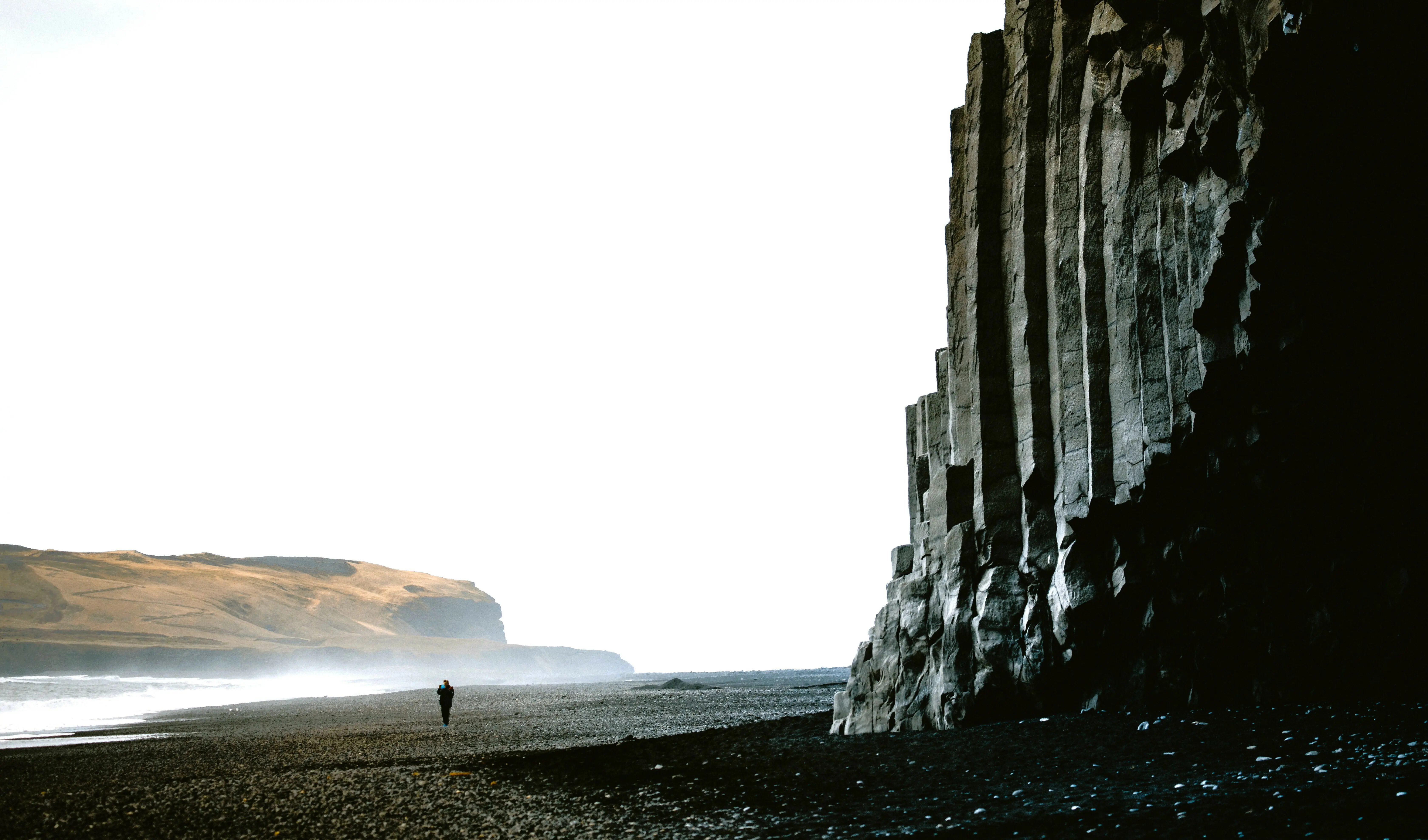 Reynisfjara, ein schwarzer Strand mit majestätischen Felsen und meer.