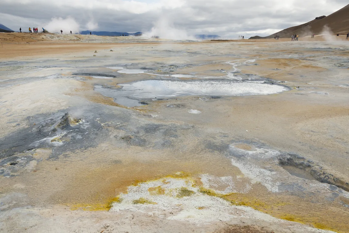 Nordisland Myvatn Hochthermalgebiet, Foto: Thomas Linkel
Löcher mit Schlacken und Schlamm und gelben Schwefelbereichen. Dampf im Hintergrund.