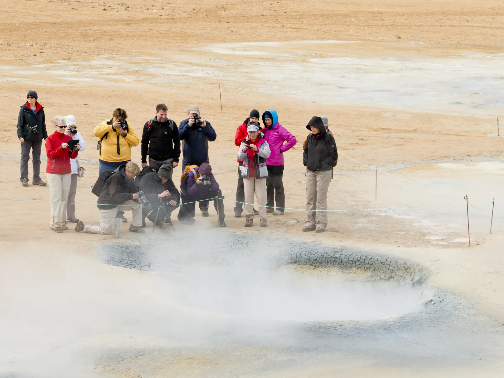11 Personen, die an einem dampfenden Krater im Hochthermalgebiet Myvatn in Nordisland stehen und Fotos machen, Foto: Thomas Linkel