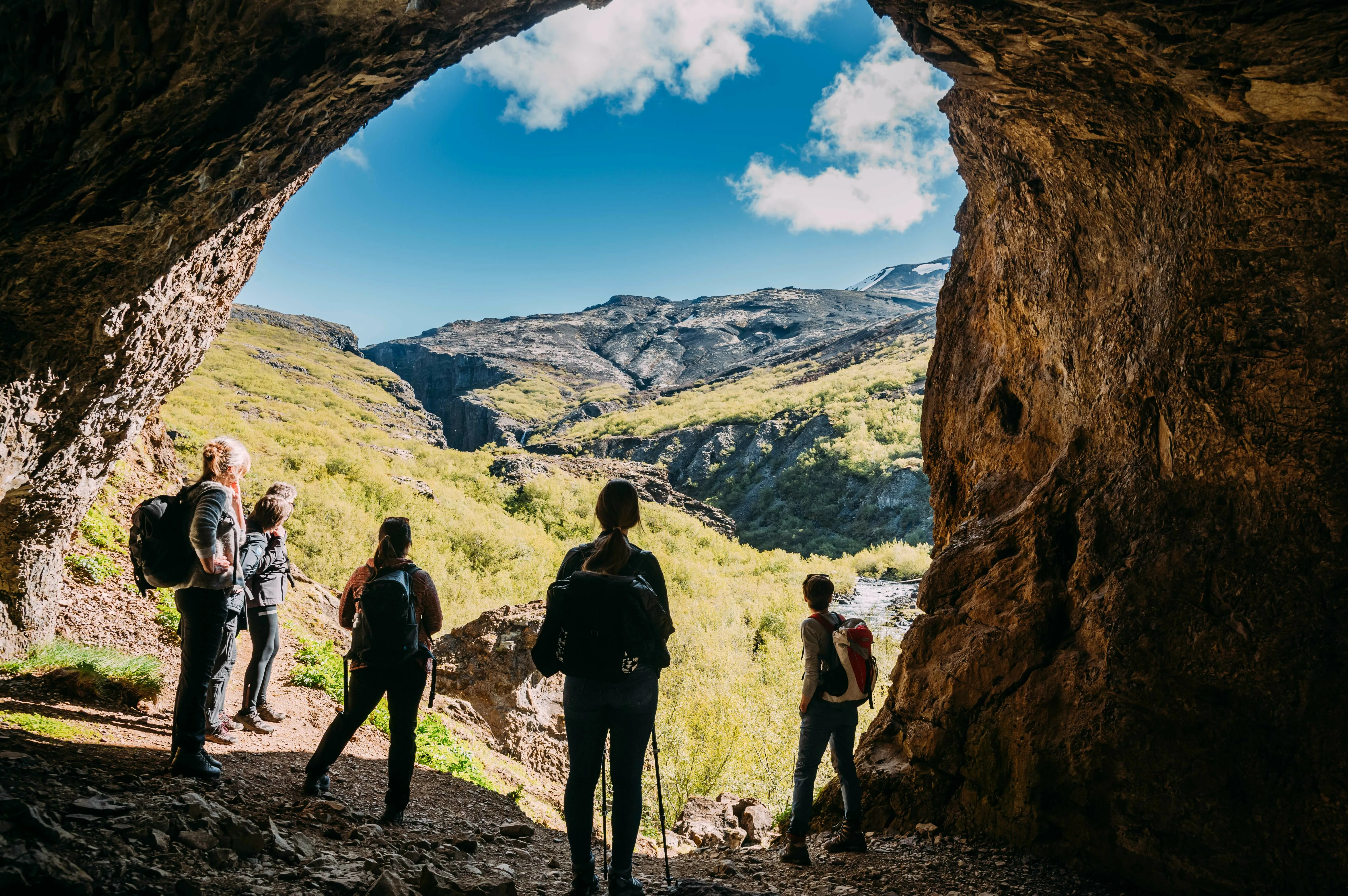 Reisegruppe  an einer Höhle beim Wandern nahe Wasserfall Glymur