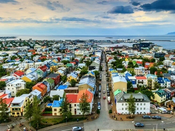 Luftaufnahme von vielen bunten Häusern in Reykjavik mit dem Meer im Hintergrund