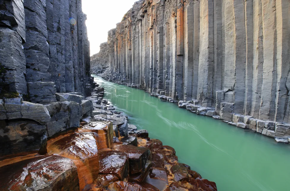 DIe Stuðlagil Schlucht in Ostisland, in der ein Türkiser Gletscherfluss zwischen wunderschönen Basaltklippen hindurchfließt