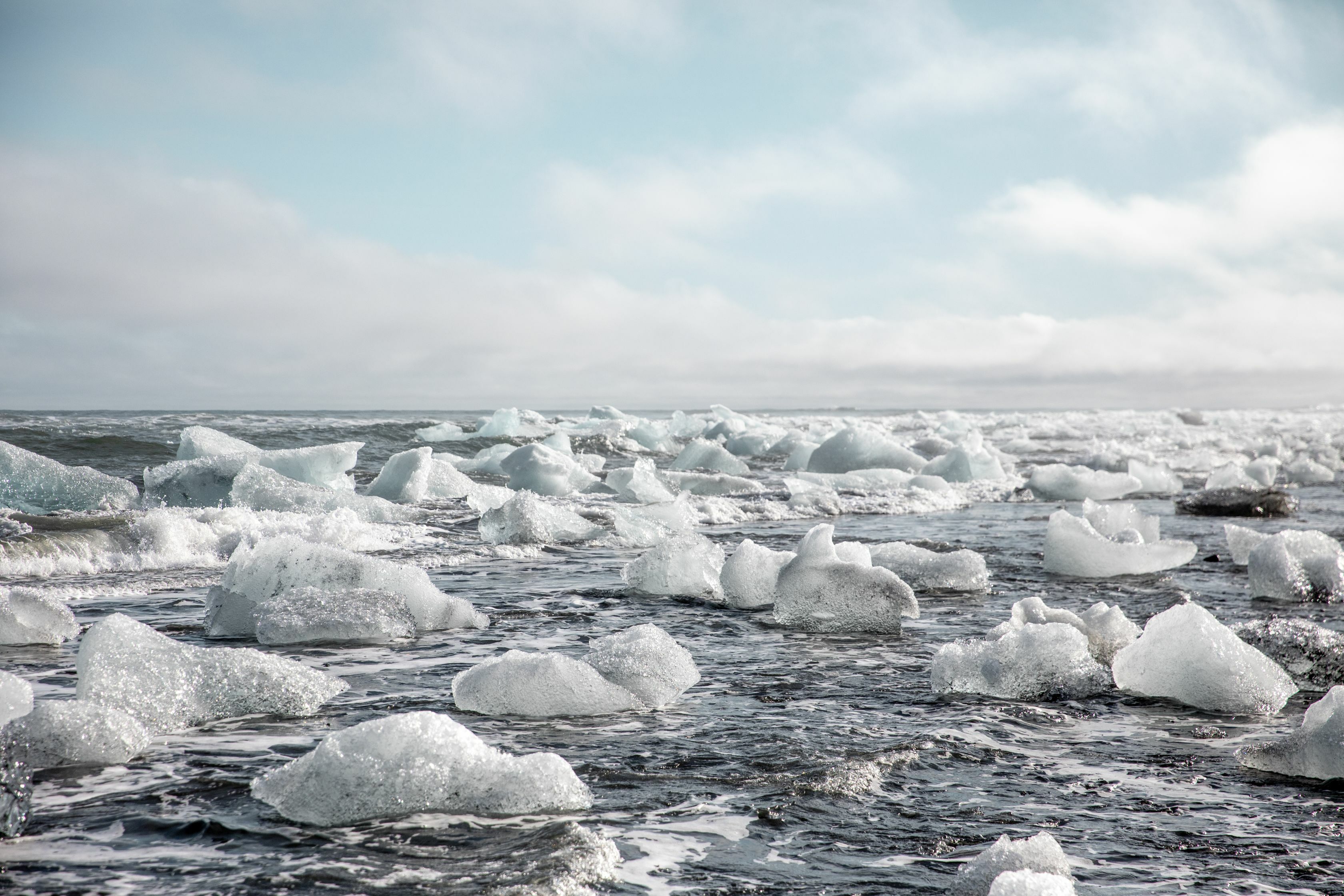 Eis der Gletscherlagune treibt im Meer bei Sonnenschein