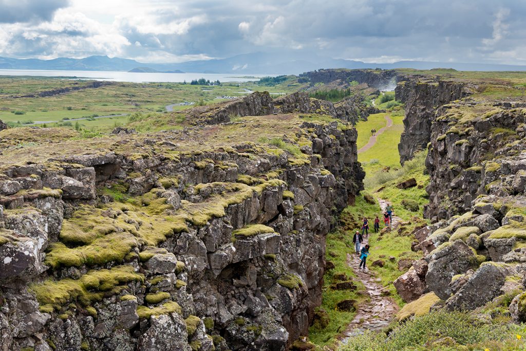 Wanderer in Erdspalte in Island mit Blick auf Landschaft